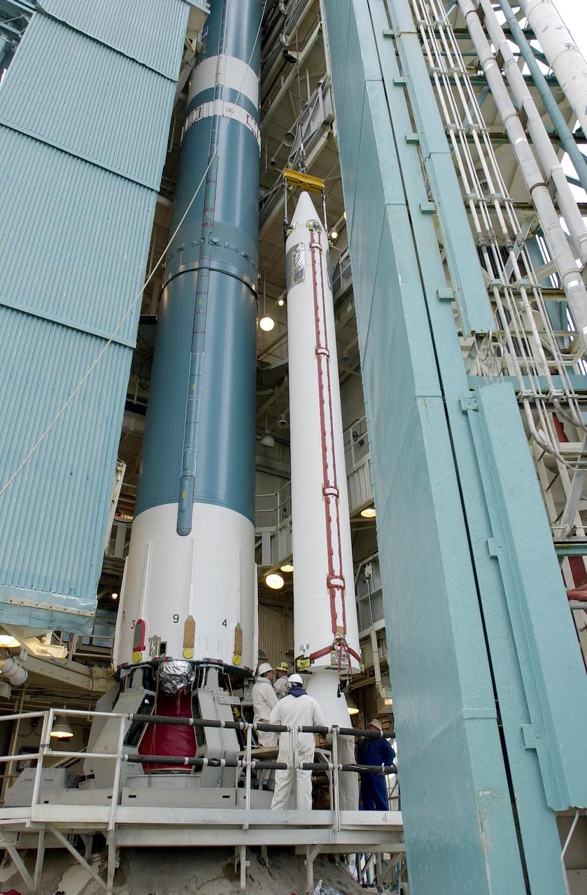 KENNEDY SPACE CENTER, FLA. - On the launch tower on NASA's Space Launch Complex 2 (SLC-2), Vandenberg Air Force Base, Calif., a solid rocket booster is lifted into an upright position beside the Delta II rocket to which it will be attached. The rocket will carry the ICESat and CHIPSat satellites into Earth orbits. ICESat is a 661-pound satellite known as Geoscience Laser Altimeter System (GLAS) that will revolutionize our understanding of ice and its role in global climate change and how we protect and understand our home planet. It will help scientists determine if the global sea level is rising or falling. It will look at the ice sheets that blanket the Earth's poles to see if they are growing or shrinking. It will assist in developing an understanding of how changes in the Earth's atmosphere and climate effect polar ice masses and global sea level. CHIPSat, a suitcase-size 131-pound satellite, will provide invaluable information into the origin, physical processes and properties of the hot gas contained in the interstellar medium. This can provide important clues about the formation and evolution of galaxies since the interstellar medium literally contains the seeds of future stars. The Delta II launch is scheduled for Jan. 11 between 4:45 p.m. - 5:30 p.m. PST.
