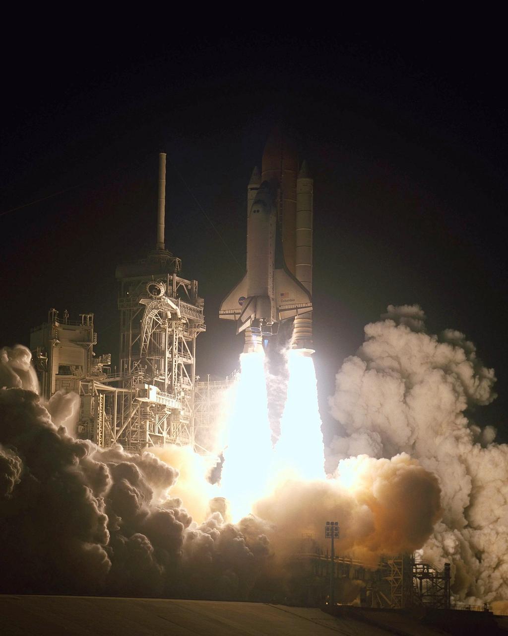 KENNEDY SPACE CENTER, Fla. - The flaming solid rocket boosters, looking like inverted torches, help hurl Space Shuttle Columbia into the pre-dawn sky on mission STS-109.   The light illuminates the Fixed Service Structure at left, with its 80-foot lightning mast on top.  .  Liftoff of Columbia occurred at 6:22:02:08 a.m. EST (11:22:02:08 GMT). This was the 27th flight of the vehicle and 108th in the history of the Shuttle program.  The goal of the mission is the maintenance and upgrade of the Hubble Space Telescope, to be carried out in five spacewalks.  The crew comprises Commander Scott D. Altman, Pilot Duane G. Carey, Payload Commander John M. Grunsfeld, and Mission Specialists Nancy Jane Currie, Richard M. Linnehan, James H. Newman and Michael J. Massimino.  After the 11-day mission, Columbia is expected to return to KSC March 12 about 4:35 a.m. EST (09:35 GMT)
