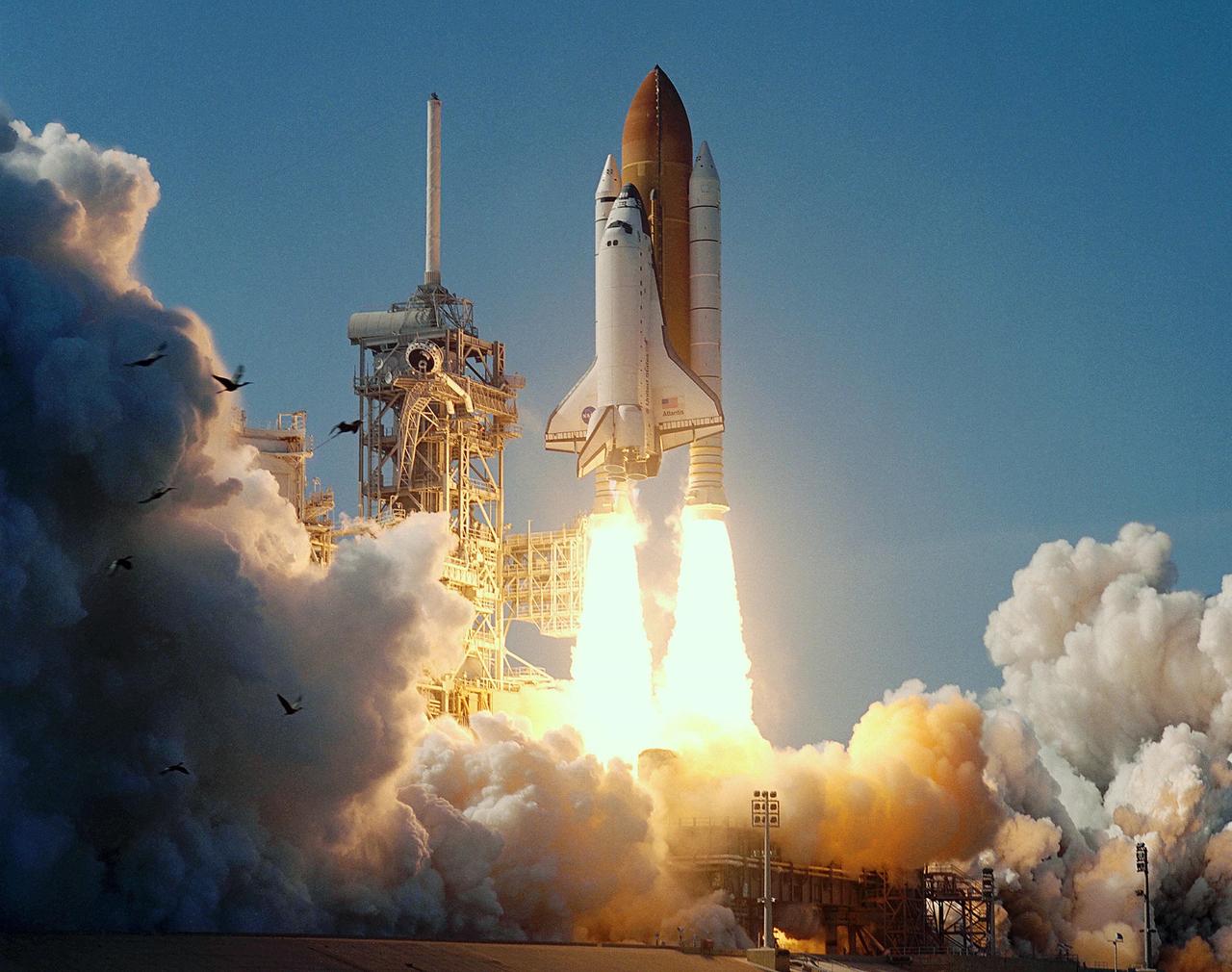KENNEDY SPACE CENTER, FLA. -- Birds - herons or storks -- in the area of Launch Pad 39B are startled into flight as Space Shuttle Atlantis roars into the sky on mission STS-110. Flames from the solid rocket boosters look like inverted torches. Liftoff occurred at 4:44:19 p.m. EDT (20:41:19 GMT).  Carrying the S0 Integrated Truss Structure and Mobile Transporter, STS-110 is the 13th assembly flight to the International Space Station.   
