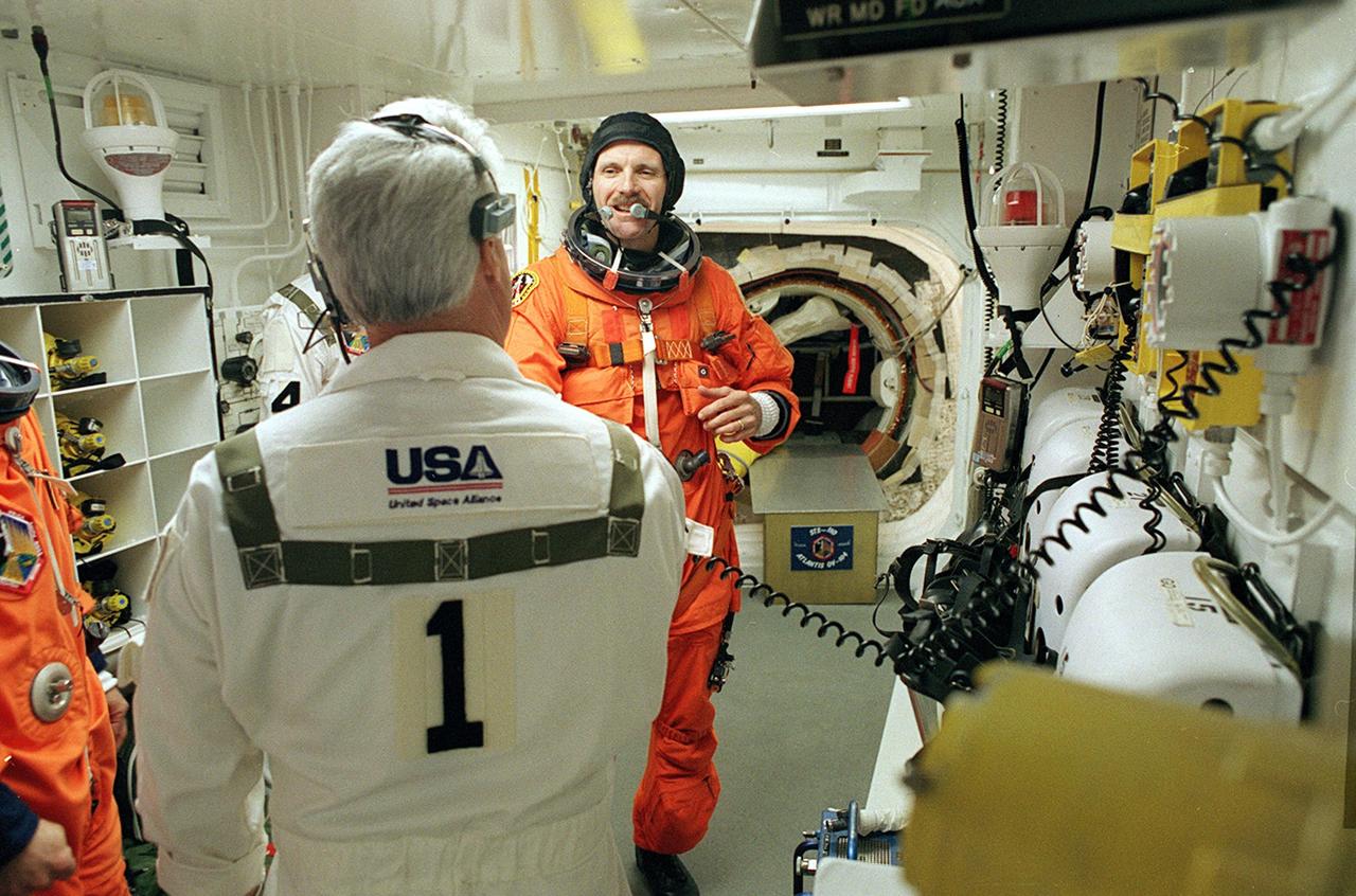 KENNEDY SPACE CENTER, FLA. -  STS-110 Mission Specialist Steven Smith is wished good luck by a member of the Closeout Crew before entering Space Shuttle Atlantis for launch. The White Room provides entry into the cockpit area of the orbiter.  This is Smith's fourth Shuttle flight. STS-110 is carrying the S0 Integrated Truss Structure and Mobile Transporter (MT) on this 13th assembly flight to the International Space Station.  On the 11-day mission, astronauts, including Smith, will make four spacewalks to attach the S0 truss, which will become the backbone of the Space Station, to the U.S. Lab, "Destiny."   The  MT, a space "railcar," is attached to the truss segment and will make its debut run during the flight.  Launch is scheduled for 4:40 p.m. EDT (20:40 GMT)