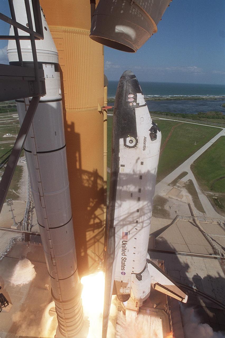 KENNEDY SPACE CENTER, FLA. - Flames erupt from beneath the solid rocket boosters as Space Shuttle Atlantis begins climbing into the clear blue sky as it launches on mission STS-110. Liftoff occurred at 4:44:19 p.m. EDT (20:41:19 GMT).  Carrying the S0 Integrated Truss Structure and Mobile Transporter, STS-110 is the 13th assembly flight to the International Space Station