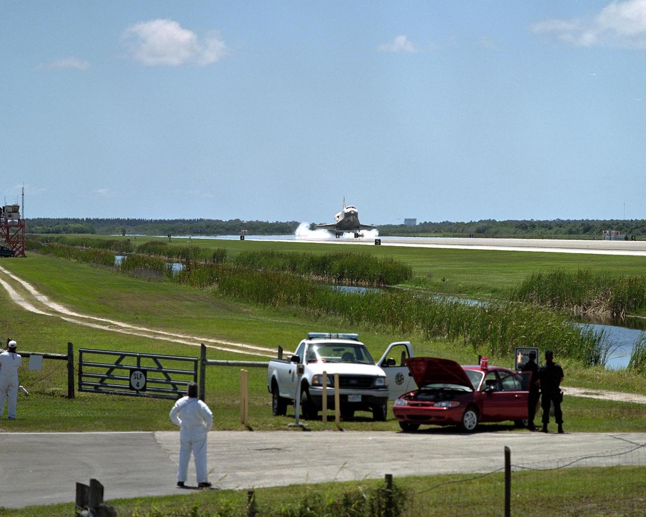 KENNEDY SPACE CENTER, FLA. - Spectators at the Shuttle Landing Facility watch Atlantis touching down on runway 33 after completing the 10-day, 19-hour, 4.5-million mile mission STS-110 to the International Space Station.   The orbiter carries the returning crew Commander Michael Bloomfield, Pilot Stephen Frick and Mission Specialists Jerry Ross, Steven Smith, Ellen Ochoa, Lee Morin and Rex Walheim.  Main gear touchdown was 12:26:57 p.m. EDT, nose gear touchdown was 12:27:09 p.m. and wheel stop was 12:28:07 p.m.  The crew delivered and installed the S0 truss, which will support cooling and power systems essential for the addition of future international laboratories, on the Station