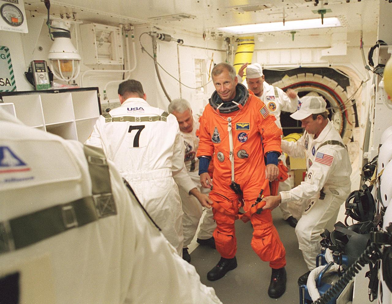 KENNEDY SPACE CENTER, FLA. -- STS-111 Commander Kenneth Cockrell is assisted by members of the Closeout Crew in the White Room before entering Space Shuttle Endeavour for launch. The White Room, at the end of the Orbiter Access Arm, provides entry into the cockpit area of the orbiter. Other crew members are Pilot Paul Lockhart, Mission Specialists Franklin Chang-Diaz and Philippe Perrin (CNES), and the Expedition Five Commander Valeri Korzun, astronaut Peggy Whitson and cosmonaut Sergei Treschev. This mission, a utilization flight, marks the 14th Shuttle flight to the International Space Station and the third Shuttle mission this year. Mission STS-111 is the 18th flight of Endeavour and the 110th flight overall in NASA's Space Shuttle program