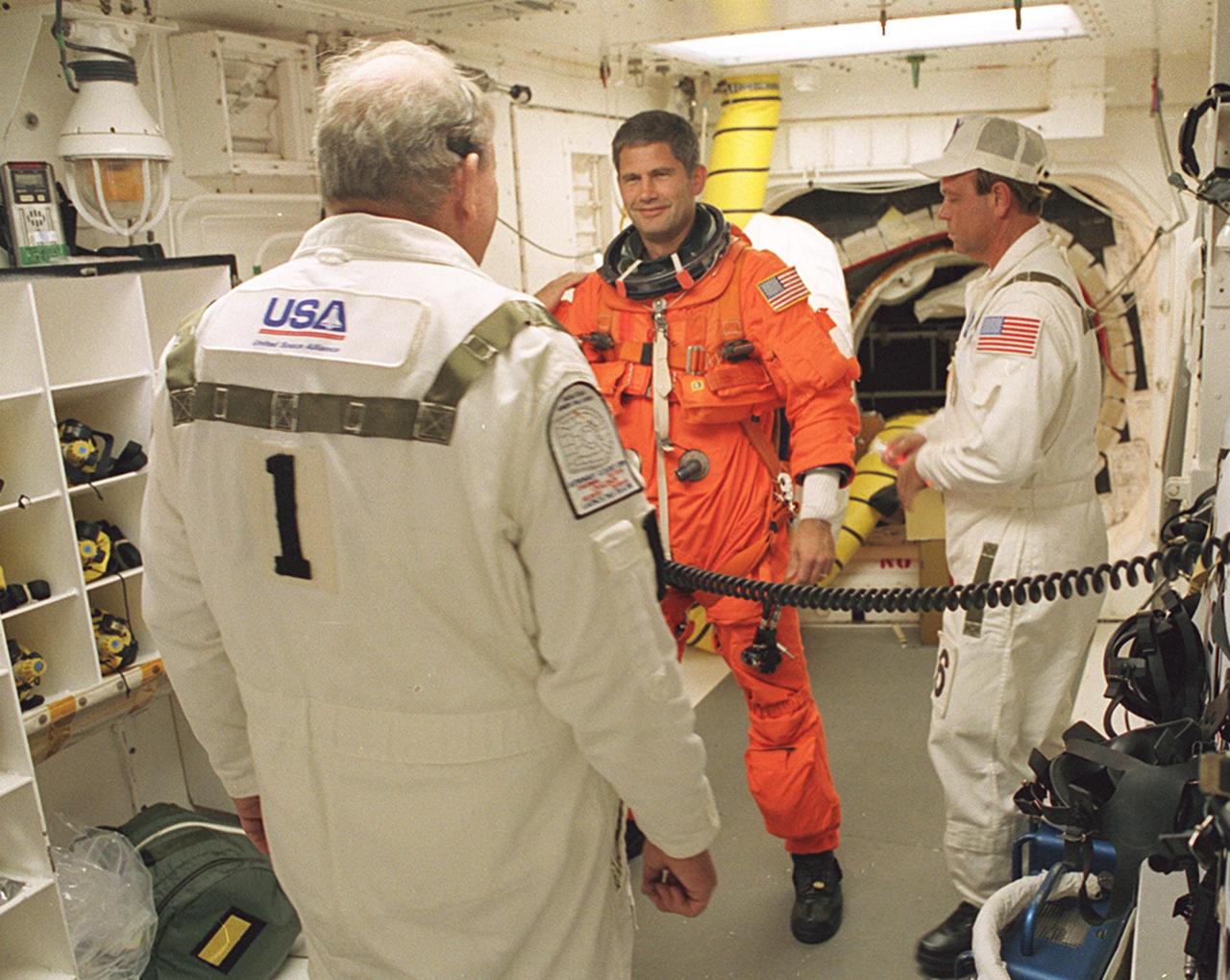 KENNEDY SPACE CENTER, FLA. -- STS-111 Pilot Paul Lockhart talks to members of the Closeout Crew in the White Room before entering Space Shuttle Endeavour for launch. The White Room, at the end of the Orbiter Access Arm, provides entry into the cockpit area of the orbiter. Other crew members are Commander Kenneth Cockrell, Mission Specialists Franklin Chang-Diaz and Philippe Perrin (CNES), and Expedition Five Commander Valeri Korzun, astronaut Peggy Whitson, and cosmonaut Sergei Treschev. This mission, a utilization flight, marks the 14th Shuttle flight to the International Space Station and the third Shuttle mission this year. Mission STS-111 is the 18th flight of Endeavour and the 110th flight overall in NASA's Space Shuttle program