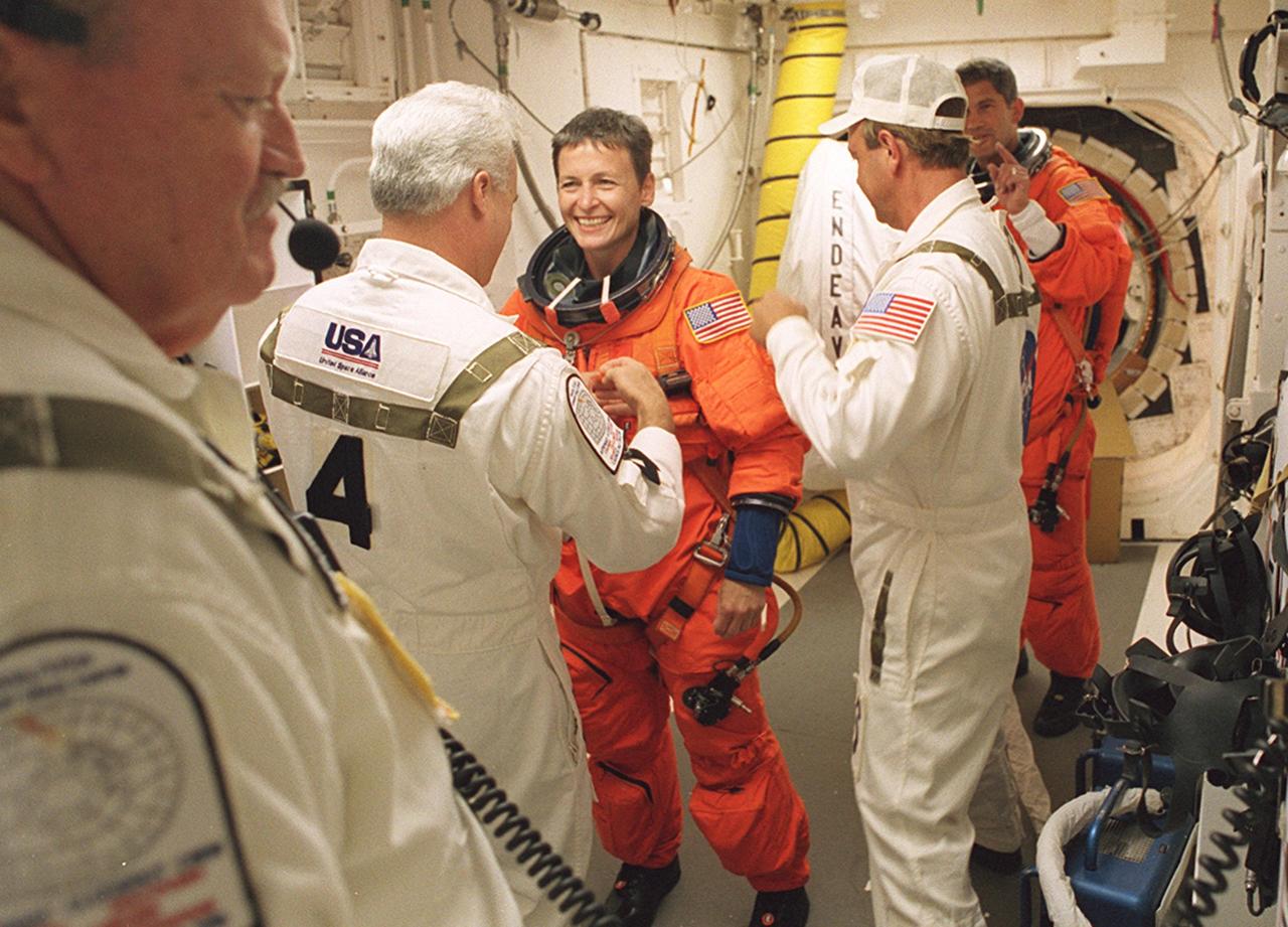 KENNEDY SPACE CENTER, FLA. -- Expedition Five astronaut Peggy Whitson talks to members of the Closeout Crew in the White Room before entering Space Shuttle Endeavour for launch of mission STS-111. STS-111 Pilot Paul Lockhart awaits his turn to enter the orbiter in the background. The White Room, at the end of the Orbiter Access Arm, provides entry into the cockpit area of the orbiter. Other crew members are Commander Kenneth Cockrell and Mission Specialists Franklin Chang-Diaz and Philippe Perrin (CNES), and Expedition Five Commander Valeri Korzun and cosmonaut Sergei Treschev. This mission, a utilization flight, marks the 14th Shuttle flight to the International Space Station and the third Shuttle mission this year. Mission STS-111 is the 18th flight of Endeavour and the 110th flight overall in NASA's Space Shuttle program