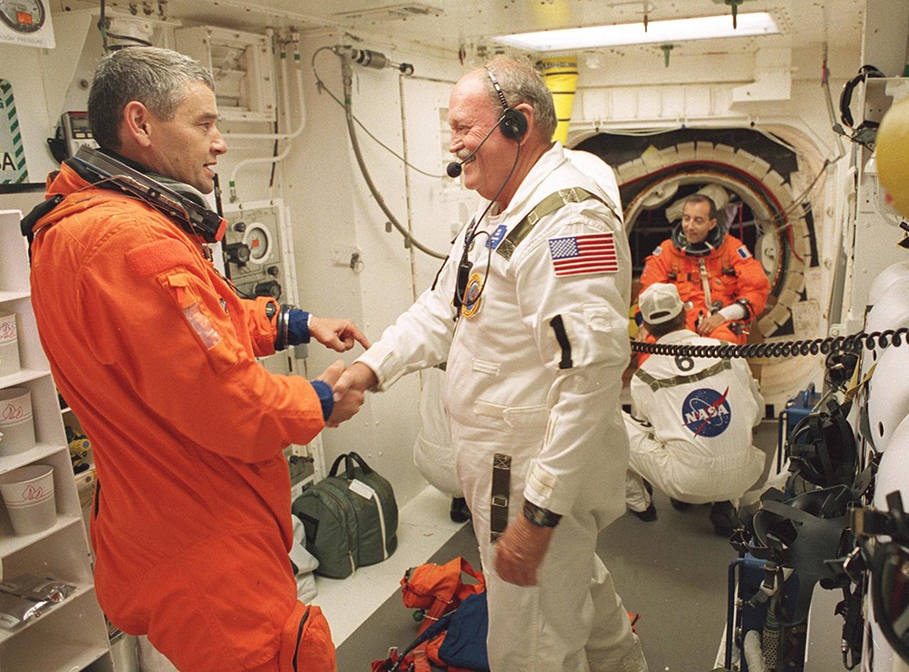 KENNEDY SPACE CENTER, FLA. -- Expedition Five Commander Valeri Korzun shakes hands with a member of the Closeout Crew in the White Room before entering Space Shuttle Endeavour for launch of mission STS-111. The White Room, at the end of the Orbiter Access Arm, provides entry into the cockpit area of the orbiter. Other crew members are Commander Kenneth Cockrell, Pilot Paul Lockhart and Mission Specialists Franklin Chang-Diaz and Philippe Perrin (CNES) , and Expedition Five astronaut Peggy Whitson and cosmonaut Sergei Treschev. This mission, a utilization flight, marks the 14th Shuttle flight to the International Space Station and the third Shuttle mission this year. Mission STS-111 is the 18th flight of Endeavour and the 110th flight overall in NASA's Space Shuttle program