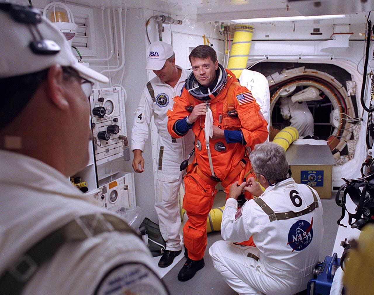 KENNEDY SPACE CENTER, FLA. - -- In the White Room at Launch Pad 39B, STS-112 Commander Jeffrey Ashby receives assistance with his spacesuit before boarding Space Shuttle Atlantis.  Liftoff is schedued for 3:46 p.m. EDT. Along with a crew of six, Atlantis will carry the S1 Integrated Truss Structure and the Crew and Equipment Translation Aid (CETA) Cart A to the International Space Station (ISS). The CETA is the first of two human-powered carts that will ride along the ISS railway, providing mobile work platforms for future spacewalking astronauts. On the 11-day mission, three spacewalks are planned to attach the S1 truss. 