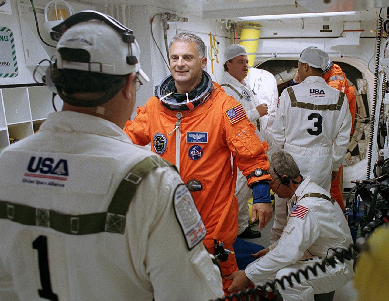 KENNEDY SPACE CENTER, FLA. - -- In the White Room at Launch Pad 39B, STS-112 Mission Specialist David A. Wolf, M.D., receives assistance with his spacesuit before boarding Space Shuttle Atlantis.  Liftoff is schedued for 3:46 p.m. EDT. Along with a crew of six, Atlantis will carry the S1 Integrated Truss Structure and the Crew and Equipment Translation Aid (CETA) Cart A to the International Space Station (ISS). The CETA is the first of two human-powered carts that will ride along the ISS railway, providing mobile work platforms for future spacewalking astronauts. On the 11-day mission, three spacewalks are planned to attach the S1 truss. 