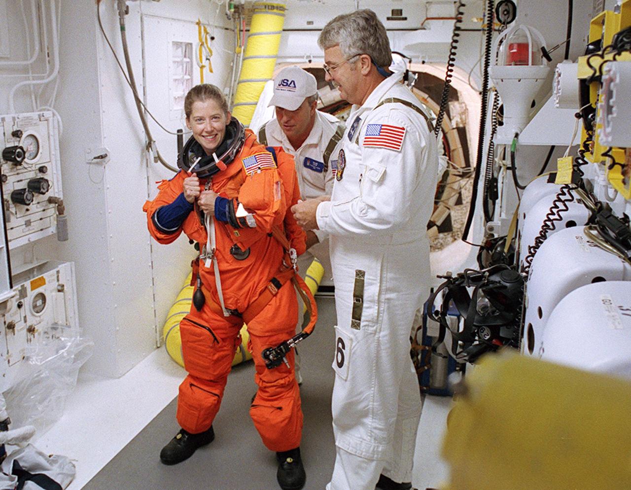 KENNEDY SPACE CENTER, FLA. - -- In the White Room at Launch Pad 39B, STS-112 Pilot Pamela Ann Melroy receives assistance with her spacesuit before boarding Space Shuttle Atlantis.  Liftoff is schedued for 3:46 p.m. EDT. Along with a crew of six, Atlantis will carry the S1 Integrated Truss Structure and the Crew and Equipment Translation Aid (CETA) Cart A to the International Space Station (ISS). The CETA is the first of two human-powered carts that will ride along the ISS railway, providing mobile work platforms for future spacewalking astronauts. On the 11-day mission, three spacewalks are planned to attach the S1 truss. 