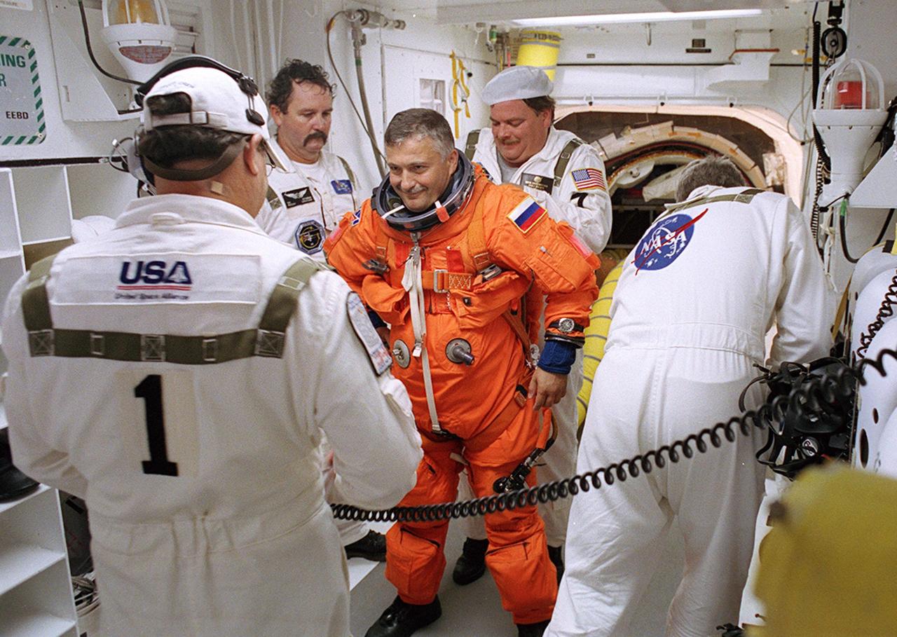 KENNEDY SPACE CENTER, FLA. - -- In the White Room at Launch Pad 39B, STS-112 Mission Specialist Fyodor N. Yurchikhin, Ph.D., a cosmonaut with the Russian Space Agency, receives assistance with his spacesuit before boarding Space Shuttle Atlantis.  Liftoff is schedued for 3:46 p.m. EDT. Along with a crew of six, Atlantis will carry the S1 Integrated Truss Structure and the Crew and Equipment Translation Aid (CETA) Cart A to the International Space Station (ISS). The CETA is the first of two human-powered carts that will ride along the ISS railway, providing mobile work platforms for future spacewalking astronauts. On the 11-day mission, three spacewalks are planned to attach the S1 truss. 
