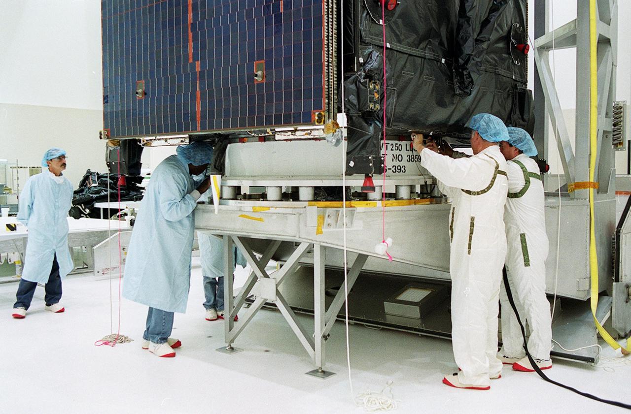 KENNEDY SPACE CENTER, FLA. -- Workers prepare to move the unpacked TDRS-J spacecraft to a workstand in the Spacecraft Assembly and Encapsulation Facility-2 (SAEF-2) for final checkout and processing before launch, currently targeted for Nov. 20. TDRS-J is the third in the current series of three Tracking and Data Relay Satellites designed to replenish the existing on-orbit fleet of six spacecraft, the first of which was launched in 1983. The Tracking and Data Relay Satellite System is the primary source of space-to-ground voice, data and telemetry for the Space Shuttle. It also provides communications with the International Space Station and scientific spacecraft in low-earth orbit, such as the Hubble Space Telescope, and launch support for some expendable vehicles. This new advanced series of satellites will extend the availability of TDRS communications services until approximately 2017. 