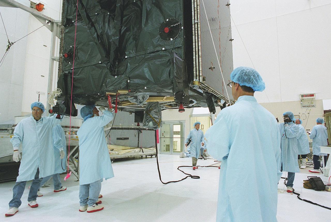 KENNEDY SPACE CENTER, FLA. --  Workers move the suspended TDRS-J spacecraft towards a workstand in the Spacecraft Assembly and Encapsulation Facility-2 (SAEF-2) for final checkout and processing before launch, currently targeted for Nov. 20. TDRS-J is the third in the current series of three Tracking and Data Relay Satellites designed to replenish the existing on-orbit fleet of six spacecraft, the first of which was launched in 1983. The Tracking and Data Relay Satellite System is the primary source of space-to-ground voice, data and telemetry for the Space Shuttle. It also provides communications with the International Space Station and scientific spacecraft in low-earth orbit, such as the Hubble Space Telescope, and launch support for some expendable vehicles. This new advanced series of satellites will extend the availability of TDRS communications services until approximately 2017. 