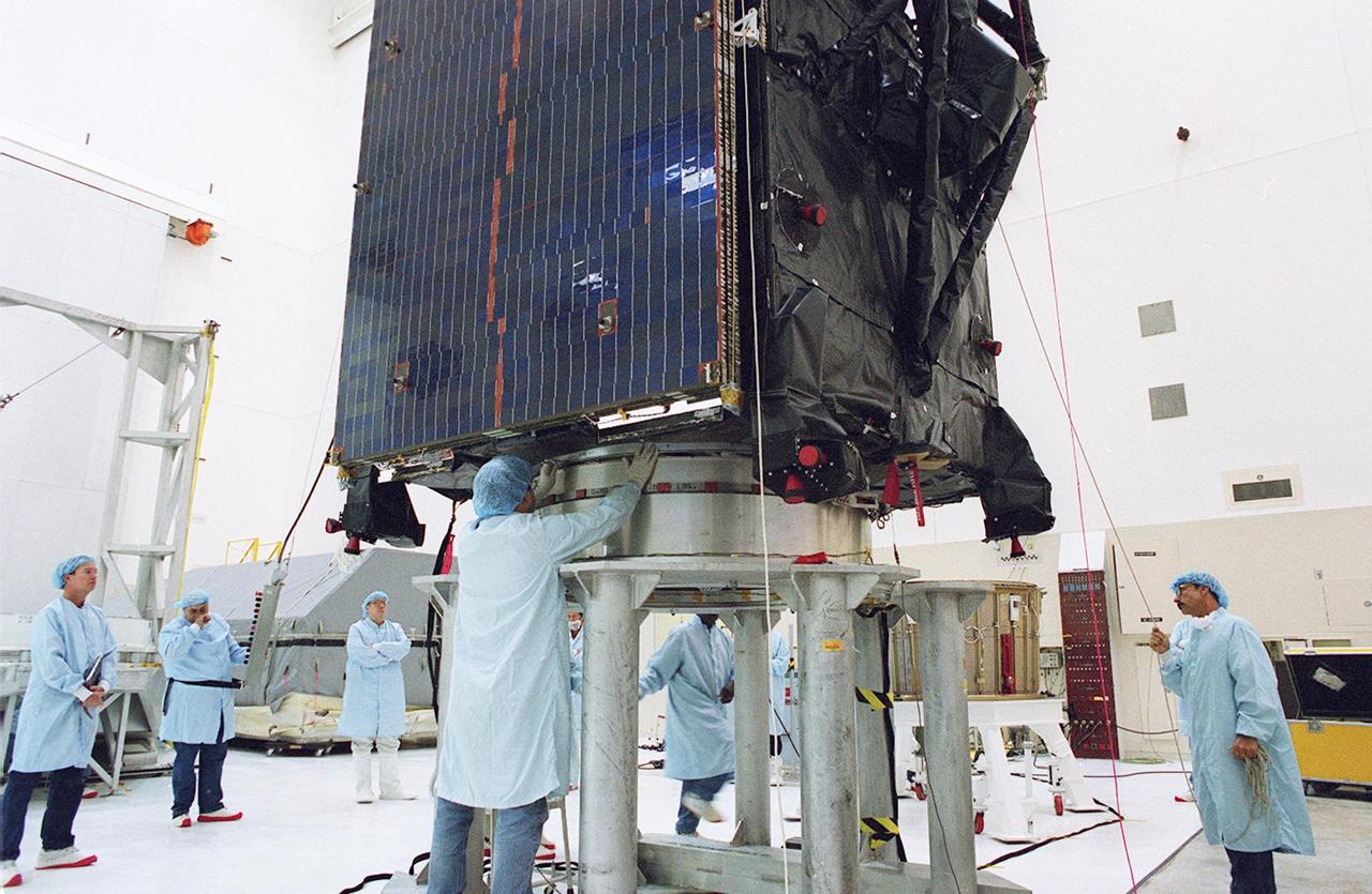 KENNEDY SPACE CENTER, FLA. --  Workers inspect the placement of the TDRS-J spacecraft on a workstand in the Spacecraft Assembly and Encapsulation Facility-2 (SAEF-2) for final checkout and processing before launch, currently targeted for Nov. 20. TDRS-J is the third in the current series of three Tracking and Data Relay Satellites designed to replenish the existing on-orbit fleet of six spacecraft, the first of which was launched in 1983. The Tracking and Data Relay Satellite System is the primary source of space-to-ground voice, data and telemetry for the Space Shuttle. It also provides communications with the International Space Station and scientific spacecraft in low-earth orbit, such as the Hubble Space Telescope, and launch support for some expendable vehicles. This new advanced series of satellites will extend the availability of TDRS communications services until approximately 2017. 