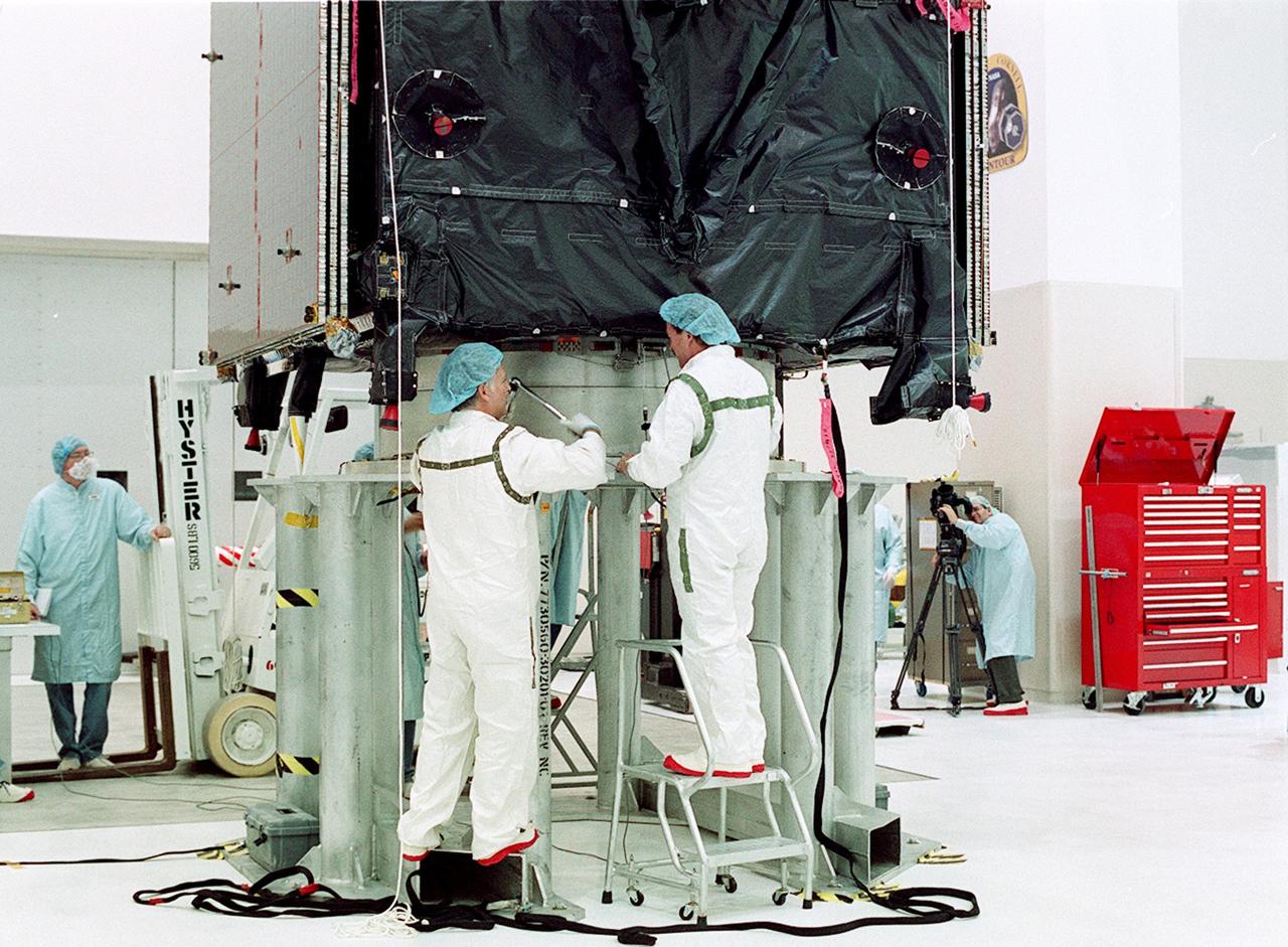 KENNEDY SPACE CENTER, FLA. --  Workers secure the TDRS-J spacecraft to a workstand in the Spacecraft Assembly and Encapsulation Facility-2 (SAEF-2) for final checkout and processing before launch, currently targeted for Nov. 20. TDRS-J is the third in the current series of three Tracking and Data Relay Satellites designed to replenish the existing on-orbit fleet of six spacecraft, the first of which was launched in 1983. The Tracking and Data Relay Satellite System is the primary source of space-to-ground voice, data and telemetry for the Space Shuttle. It also provides communications with the International Space Station and scientific spacecraft in low-earth orbit, such as the Hubble Space Telescope, and launch support for some expendable vehicles. This new advanced series of satellites will extend the availability of TDRS communications services until approximately 2017. 