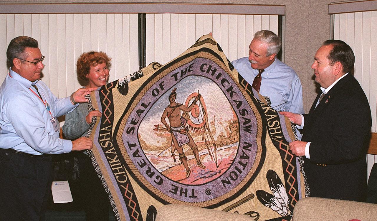 KENNEDY SPACE CENTER, FLA. -- During an administrator's briefing at the IMAX 2 theatre, Lt. Gov. Jefferson Keel of the Chickasaw Nation (far left) presents a blanket with the seal of the Chickasaw Nation to NASA Administrator Sean O'Keefe (second from right).  Next to O'Keefe is Chickasaw Gov. Bill Anoatubby.  Next to Gov. Keel is Mrs. Laura O'Keefe. STS-113 Mission Specialist John Herrington is a tribally enrolled Chickasaw and the world's first Native American astronaut. Kennedy Space Center hosted more than 350 Native Americans in  STS-113 prelaunch events surrounding the historic mission assignment of  Herrington.  