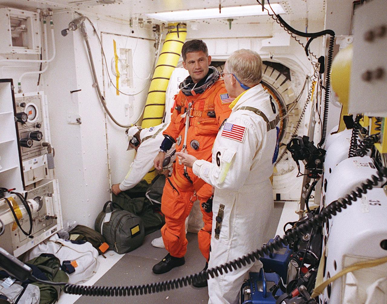 KENNEDY SPACE CENTER, FLA. -- In the White Room on Launch Pad 39A, STS-113 Pilot Paul Lockhart is helped by Danny Wyatt (foreground) with his launch and entry suit before entering Space Shuttle Endeavour. Wyatt is the NASA Quality Assurance specialist with the Closeout Crew. The launch will carry the Expedition 6 crew to the Station and return the Expedition 5 crew to Earth. The major objective of the mission is delivery of the Port 1 (P1) Integrated Truss Assembly, which will be attached to the port side of the S0 truss. Three spacewalks are planned to install and activate the truss and its associated equipment. Launch of Space Shuttle Endeavour on mission STS-113 is scheduled for Nov. 23 at 7:50 p.m. EST.
