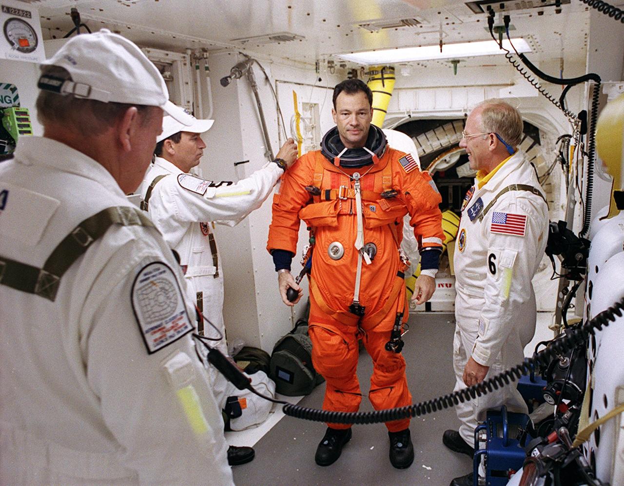 KENNEDY SPACE CENTER, FLA. -- In the White Room on Launch Pad 39A, STS-113 Mission Specialist Michael Lopez-Alegria is helped with his launch and entry suit before entering Space Shuttle Endeavour. Closeout Crew members helping are (from left) Rick Welty, United Space Alliance Vehicle Closeout chief, Bobby Wright, USA mechanical technician, and Danny Wyatt, NASA Quality Assurance specialist. The launch will carry the Expedition 6 crew to the Station and return the Expedition 5 crew to Earth. The major objective of the mission is delivery of the Port 1 (P1) Integrated Truss Assembly, which will be attached to the port side of the S0 truss. Three spacewalks are planned to install and activate the truss and its associated equipment. Launch of Space Shuttle Endeavour on mission STS-113 is scheduled for Nov. 23 at 7:50 p.m. EST.