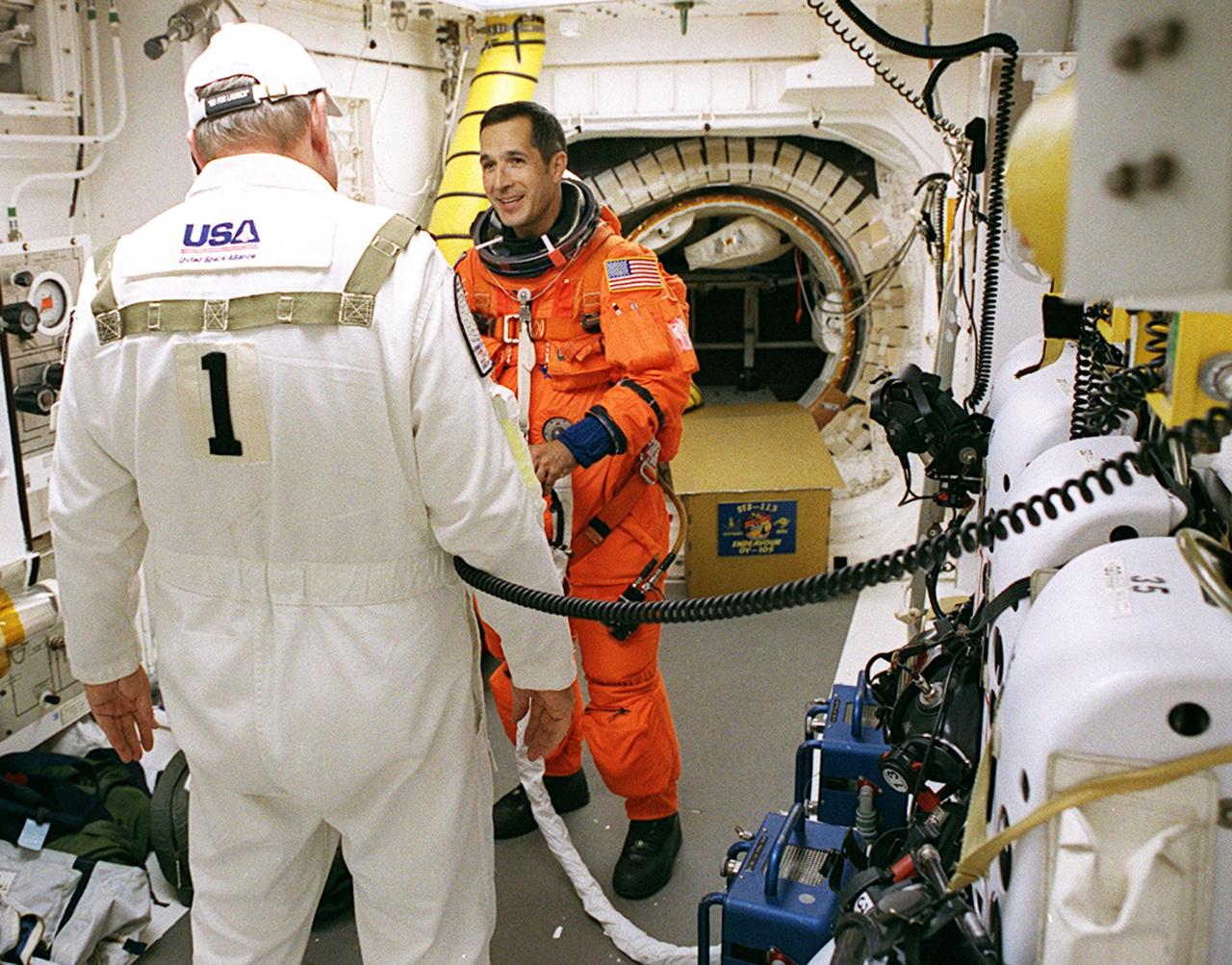 KENNEDY SPACE CENTER, FLA. -- In the White Room on Launch Pad 39A, STS-113 Mission Specialist John Herrington is helped with his launch and entry suit by Rick Welty, United Space Alliance Vehicle Closeout chief. The launch will carry the Expedition 6 crew to the Station and return the Expedition 5 crew to Earth. The major objective of the mission is delivery of the Port 1 (P1) Integrated Truss Assembly, which will be attached to the port side of the S0 truss. Three spacewalks are planned to install and activate the truss and its associated equipment. Launch of Space Shuttle Endeavour on mission STS-113 is scheduled for Nov. 23 at 7:50 p.m. EST.