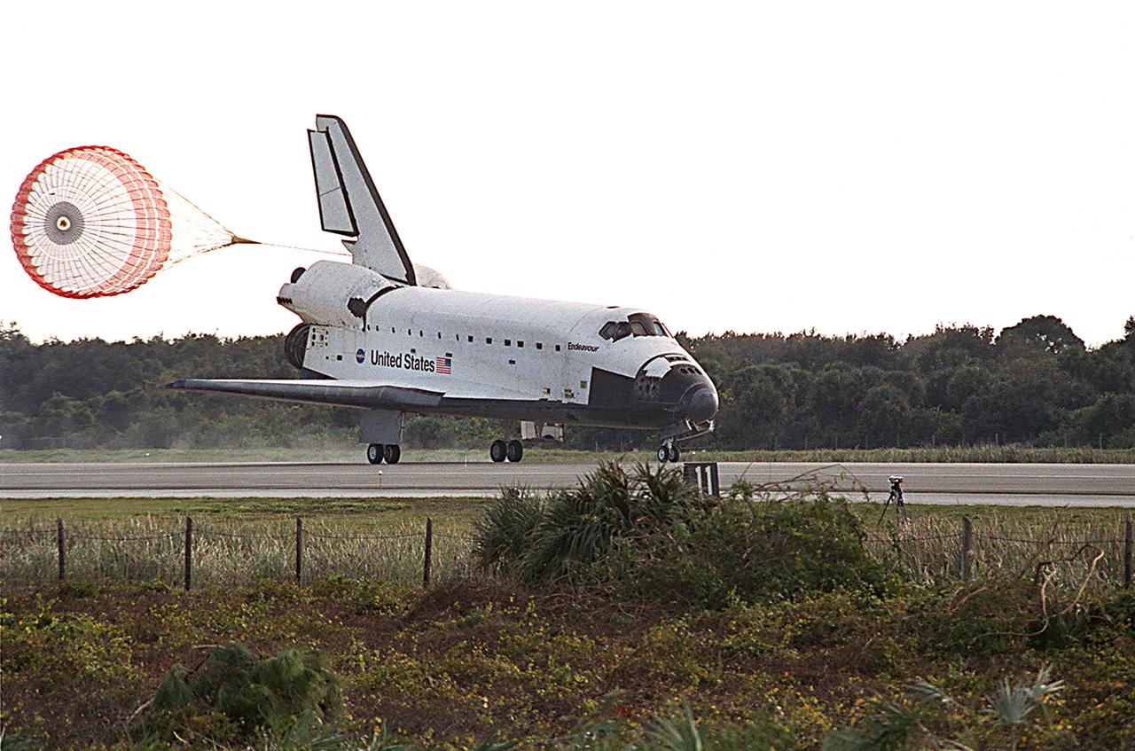 KENNEDY SPACE CENTER, FLA. -- The drag chute trails Space Shuttle Endeavour after touch down on runway 33 at the Shuttle Landing Facility, bringing to a close the 13-day, 18-hour, 48-minute, 5.74-million mile STS-113 mission to the International Space Station. Main gear touchdown was at 2:37:12 p.m. EST, nose gear touchdown was at 2:37:23 p.m., and wheel stop was at 2:38:25 p.m. Poor weather conditions thwarted landing opportunities until a fourth day, the first time in Shuttle program history that a landing has been waved off for three consecutive days. The vehicle carries the STS-113 crew, Commander James Wetherbee, Pilot Paul Lockhart and Mission Specialists Michael Lopez-Alegria and John Herrington, as well as the returning Expedition Five crew, Commander Valeri Korzun, ISS Science Officer Peggy Whitson and Flight Engineer Sergei Treschev. The installation of the P1 truss on the International Space Station was accomplished during the mission.