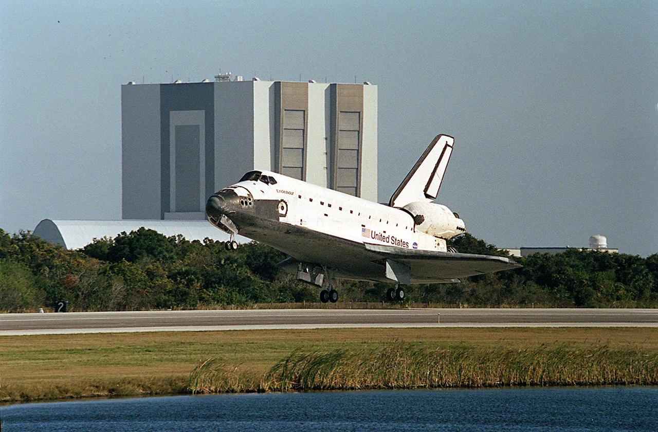 KENNEDY SPACE CENTER, FLA. -- Space Shuttle Endeavour is moments away from touch down on runway 33 at the Shuttle Landing Facility, bringing to a close the 13-day, 18-hour, 48-minute, 5.74-million mile STS-113 mission to the International Space Station. In the background is a KSC landmark: the Vehicle Assembly Building. Main gear touchdown was at 2:37:12 p.m. EST, nose gear touchdown was at 2:37:23 p.m., and wheel stop was at 2:38:25 p.m. Poor weather conditions thwarted landing opportunities until a fourth day, the first time in Shuttle program history that a landing has been waved off for three consecutive days. The vehicle carries the STS-113 crew, Commander James Wetherbee, Pilot Paul Lockhart and Mission Specialists Michael Lopez-Alegria and John Herrington, as well as the returning Expedition Five crew, Commander Valeri Korzun, ISS Science Officer Peggy Whitson and Flight Engineer Sergei Treschev. The installation of the P1 truss on the International Space Station was accomplished during the mission.