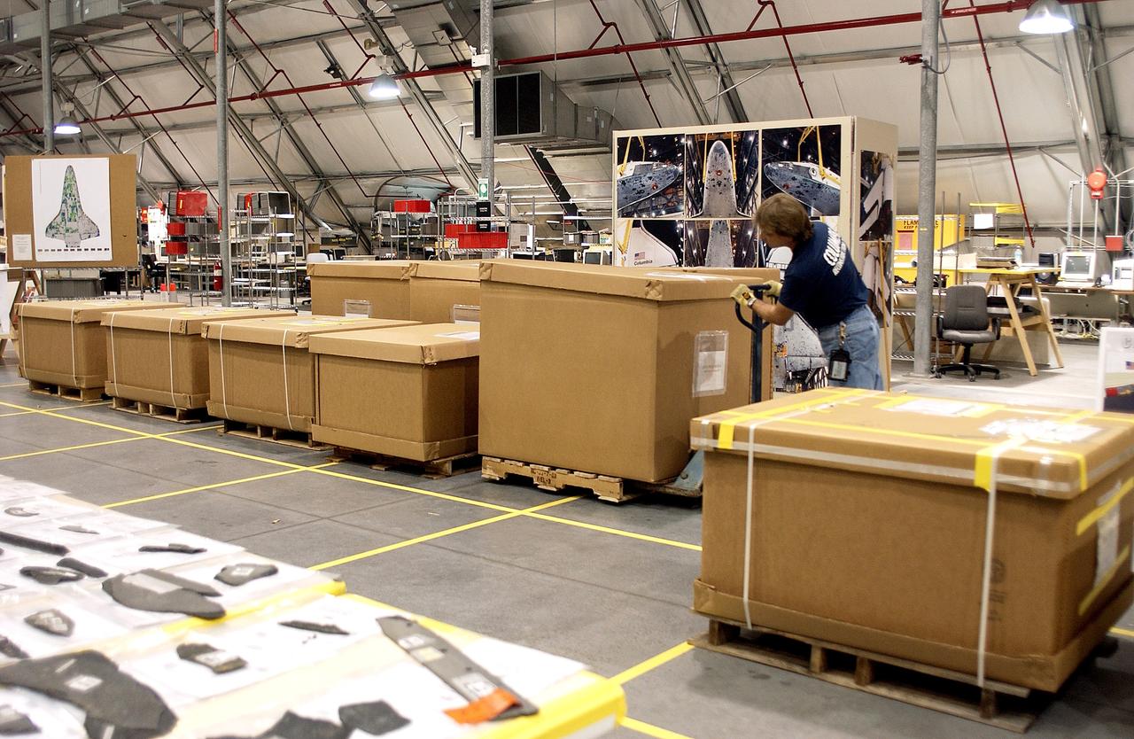 KENNEDY SPACE CENTER, FLA. -   In the Columbia Debris Hangar, Jack Nowling moves a box filled with part of the Columbia debris.  About 83,000 pieces were shipped to KSC during search and recovery efforts in East Texas. An area of the Vehicle Assembly Building is being prepared to store the debris.