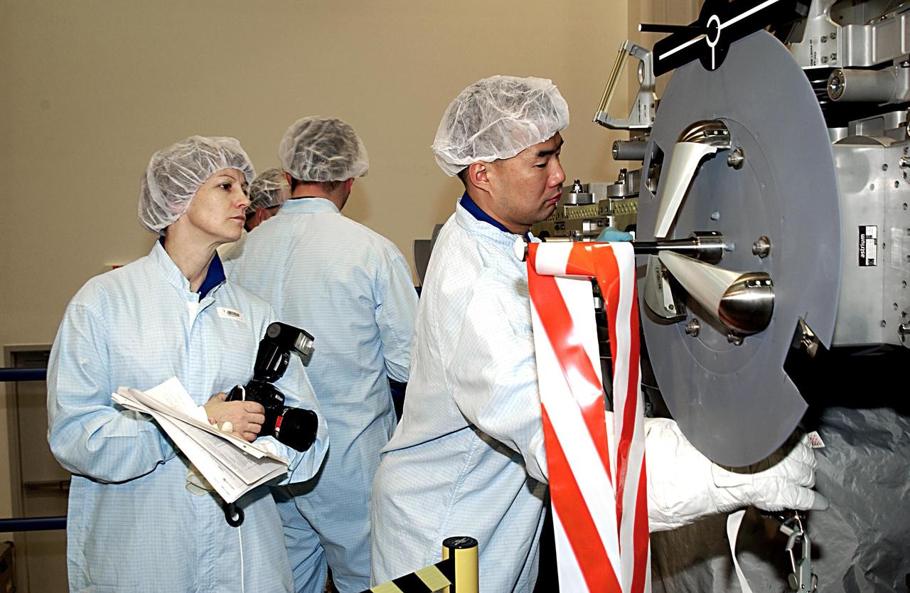 KENNEDY SPACE CENTER, FLA. - At the SPACEHAB facility in Cape Canaveral, STS-114 Commander Eileen Collins (Colonel, USAF) (left foreground) looks on as Mission Specialist Soichi Noguchi (right), of the National Space Development Agency of Japan (NASDA), familiarizes himself with the hardware that will fly on the STS-114 mission. STS-114 is a utilization and logistics flight that will carry Multi-Purpose Logistics Module Raffaello and the External Stowage Platform (ESP-2), as well as the Expedition 7 crew, to the International Space Station. Launch is targeted for March 1, 2003.