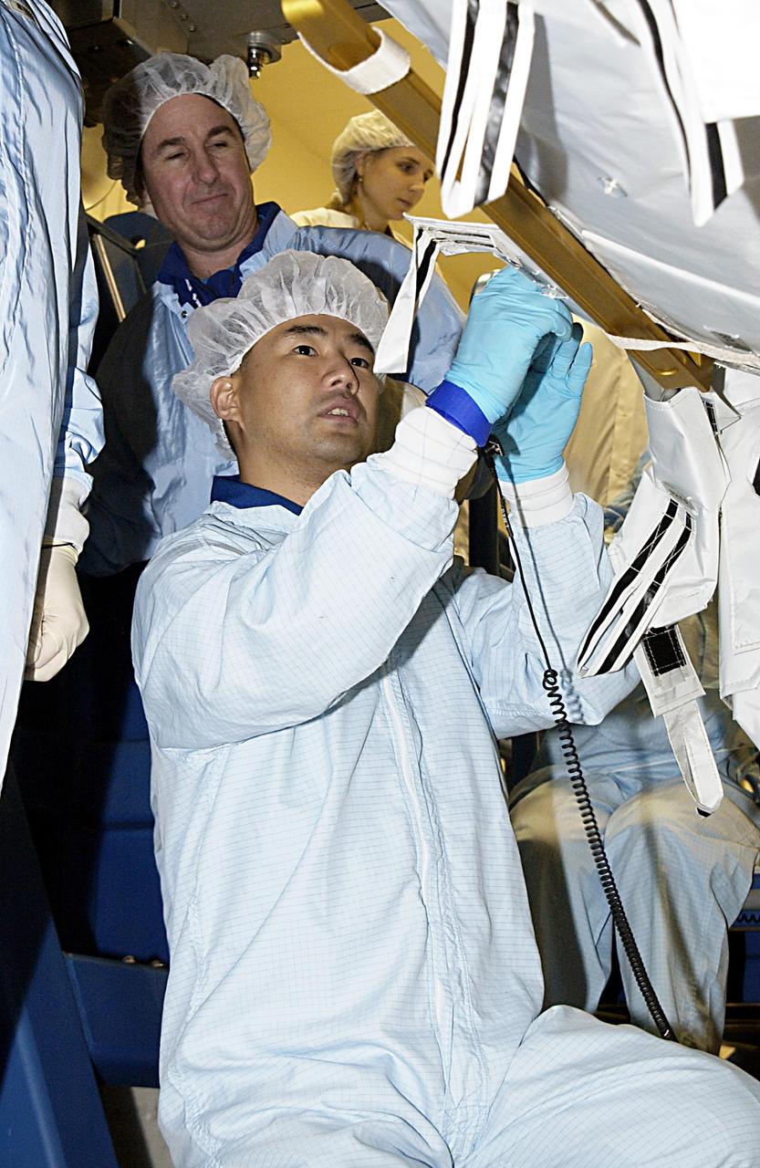KENNEDY SPACE CENTER, FLA. - At the SPACEHAB facility in Cape Canaveral, STS-114 Mission Specialist Stephen K. Robinson, Ph.D., (left) looks on as Mission Specialist Soichi Noguchi (foreground), with the National Space Development Agency of Japan (NASDA), familiarizes himself with the hardware that will fly on the STS-114 mission. STS-114 is a utilization and logistics flight that will carry Multi-Purpose Logistics Module Raffaello and the External Stowage Platform (ESP-2), as well as the Expedition 7 crew, to the International Space Station. Launch is targeted for March 1, 2003.