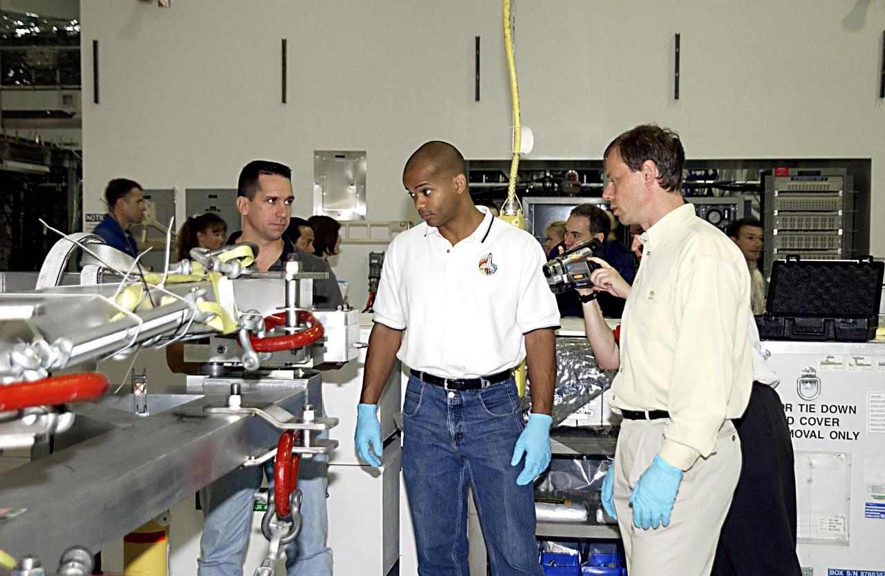 KENNEDY SPACE CENTER, FLA. - In the Space Station Processing Facility, STS-116 Pilot William Oefelein (left), Mission Specialists Robert Curbeam (center) and Christer Fuglesang (right) check out equipment for the mission during a Crew Equipment Interface Test activity.  Fuglesang is with the European Space Agency. Mission STS-116 is the 19th assembly flight to the International Space Station, delivering the third port truss segment, the P5 Truss, that will be attached to the second port truss segment, the P3/P4 Truss.  The mission will also deliver the eighth expedition crew to the ISS and return Expedition 7.  STS-116 is scheduled for launch July 24, 2003.  