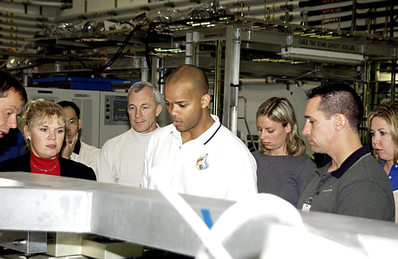 KENNEDY SPACE CENTER, FLA. - In the Space Station Processing Facility, STS-116 Mission Specialist Robert Curbeam (center, foreground) and Pilot William Oefelein (right, foreground), check out equipment for the mission during a Crew Equipment Interface Test activity. Mission STS-116 is the 19th assembly flight to the International Space Station, delivering the third port truss segment, the P5 Truss, that will be attached to the second port truss segment, the P3/P4 Truss. The mission will also deliver the eighth expedition crew to the ISS and return Expedition 7. STS-116 is scheduled for launch July 24, 2003.