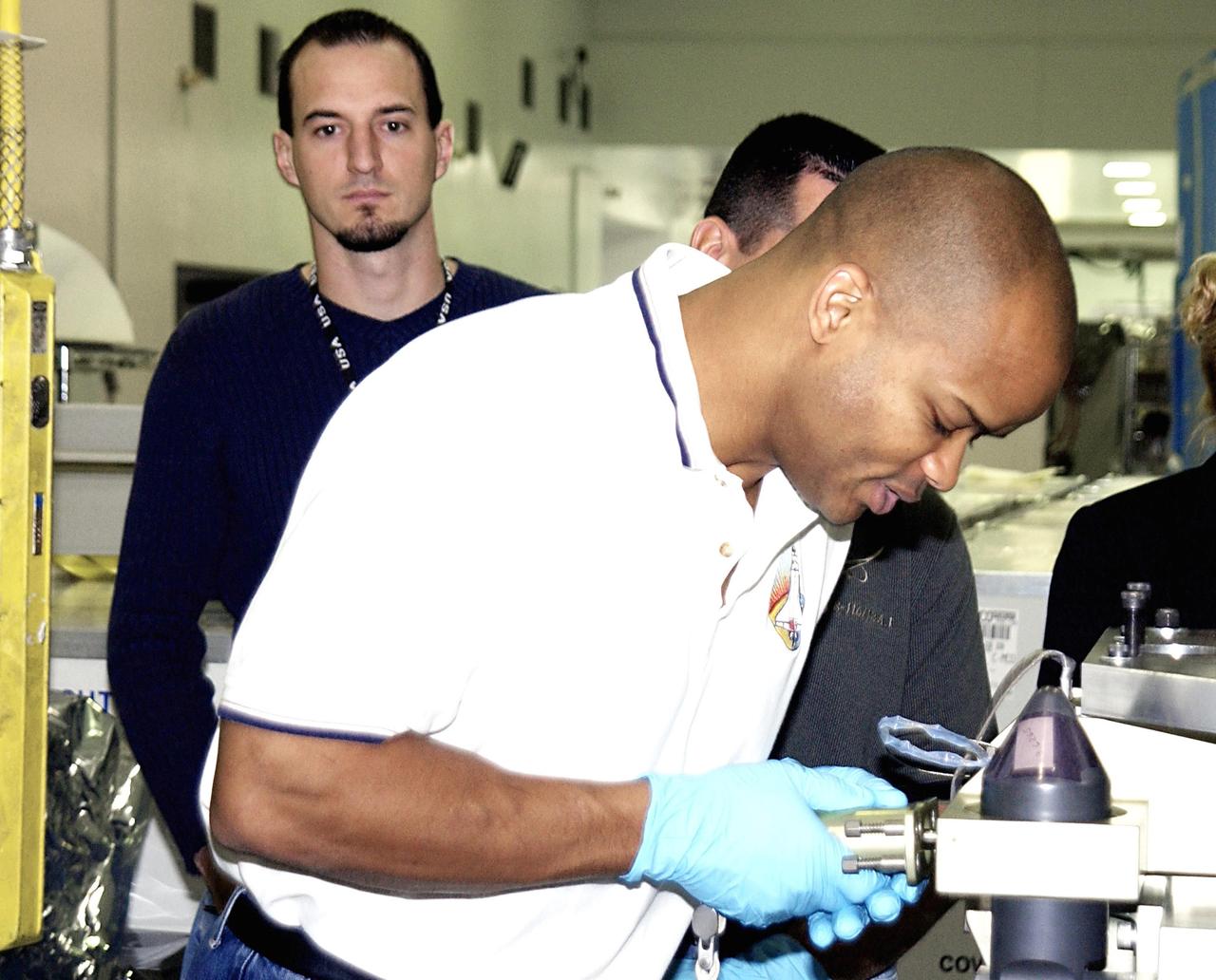 KENNEDY SPACE CENTER, FLA. - In the Space Station Processing Facility, STS-116 Mission Specialist Robert Curbeam works on equipment for the mission during a Crew Equipment Interface Test activity. Mission STS-116 is the 19th assembly flight to the International Space Station, delivering the third port truss segment, the P5 Truss, that will be attached to the second port truss segment, the P3/P4 Truss. The mission will also deliver the eighth expedition crew to the ISS and return Expedition 7. STS-116 is scheduled for launch July 24, 2003.
