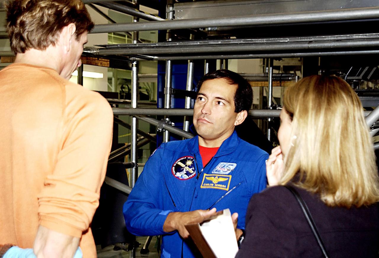 KENNEDY SPACE CENTER, FLA. -  STS-119 Mission Specialists Carlos Noriega (center) and Michael Gernhardt (left) discuss mission information during a Crew Equipment Interface Test activity.  The mission will deliver the fourth and final set of U.S. solar arrays along with the fourth starboard truss segment, the S6 truss.  Mission STS-119 is scheduled to launch in January 2004.  