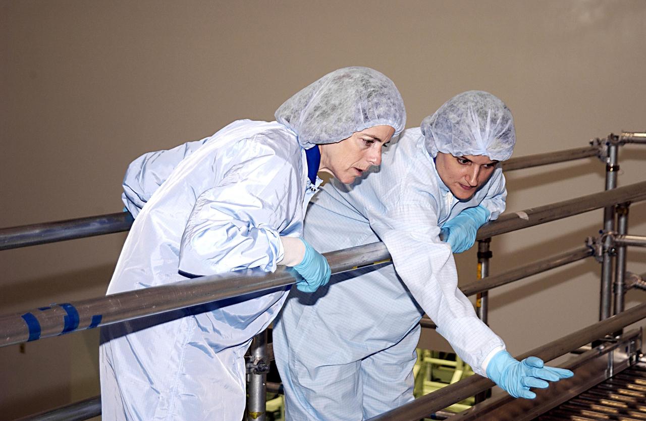 KENNEDY SPACE CENTER, FLA. - STS-118 Mission Specialist Barbara Morgan (left) listens to a technician in the Space Station Processing Facility during Crew Equipment Interface Test activities. Morgan was selected by NASA in January 1998 as the first Educator Astronaut. The mission to the International Space Station will be delivering the third starboard truss segment, the ITS S5, which will be attached to the station, and a SPACEHAB Single Cargo Module with supplies and equipment. Launch aboard Space Shuttle Columbia is scheduled for Nov. 13, 2003.