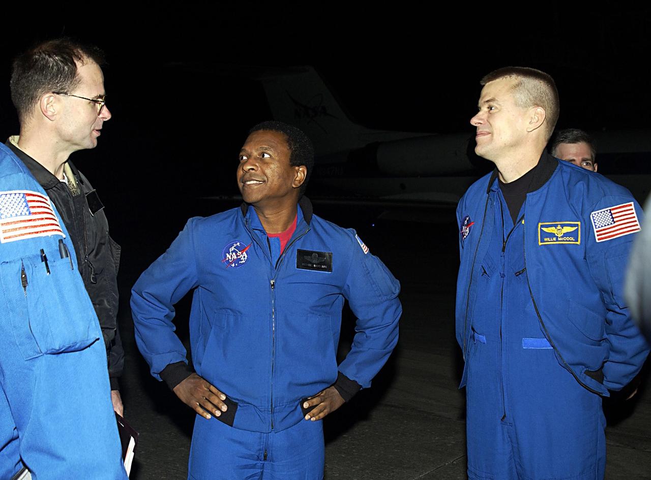 KENNEDY SPACE CENTER, FLA. - After their arrival at KSC, STS-107 Payload Commander Michael Anderson (center) and Pilot William "Willie" McCool (right) talk with Robert Hanley, who is mission lead with the Vehicle Integration Test team from Houston. STS-107 is a mission devoted to research and will include more than 80 experiments that will study Earth and space science, advanced technology development, and astronaut health and safety. The payload on Space Shuttle Columbia includes FREESTAR (Fast Reaction Experiments Enabling Science, Technology, Applications and Research) and the SHI Research Double Module (SHI/RDM), known as SPACEHAB. Experiments on the module range from material sciences to life sciences. Launch of Columbia is targeted for Jan. 16 between 10 a.m. and 2 p.m.