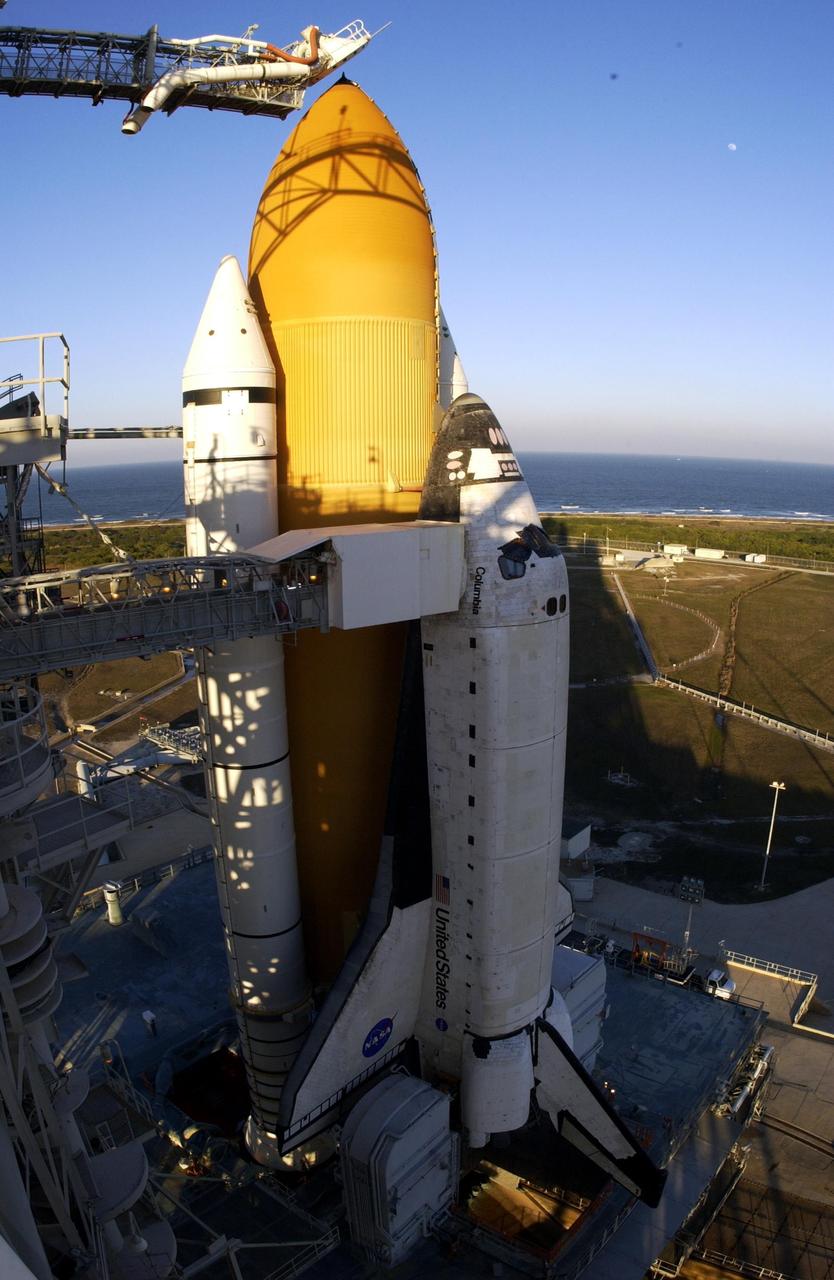 KENNEDY SPACE CENTER, FLA. -- The late afternoon sun highlights the external tank and solid rocket booster on Space Shuttle Columbia after rollback of the Rotating Service Structure on Launch Pad 39A. Visible are the orbiter access arm with the White Room extended to Columbia's cockpit, and at the top, the gaseous oxygen vent arm and cap, called the "beanie cap." Columbia is scheduled for launch Jan. 16 at 10:39 a.m. EST on mission STS-107, a research mission.