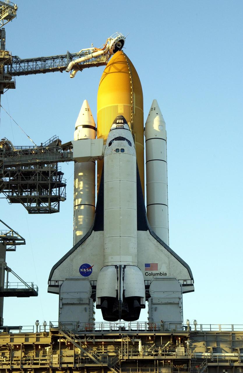KENNEDY SPACE CENTER, FLA. -- The late afternoon sun highlights the external tank and solid rocket booster on Space Shuttle Columbia after rollback of the Rotating Service Structure on Launch Pad 39A. Visible are the orbiter access arm with the White Room extended to Columbia's cockpit, and at the top, the gaseous oxygen vent arm and cap, called the "beanie cap." Columbia is scheduled for launch Jan. 16 at 10:39 a.m. EST on mission STS-107, a research mission.