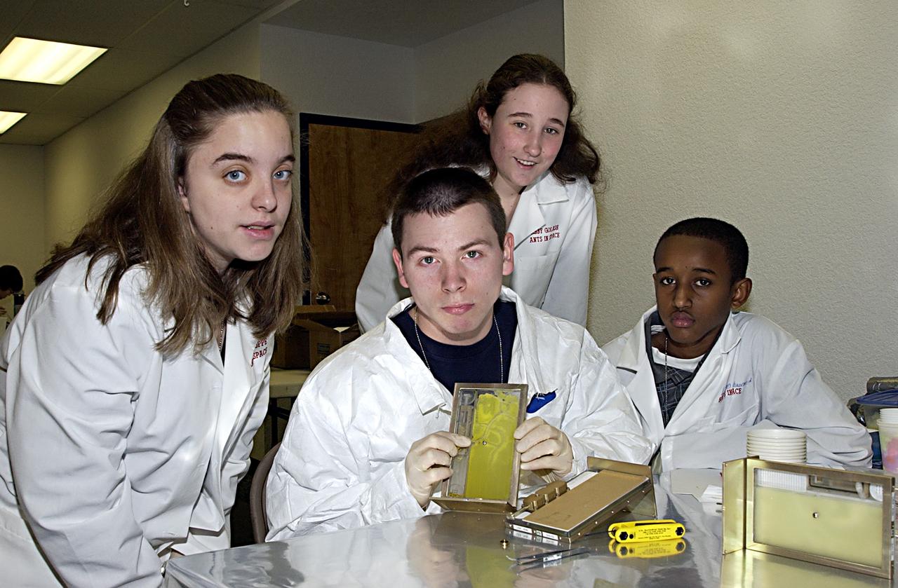 Students display an experiment that will fly in SPACEHAB on Space Shuttle Columbia on mission STS-107. SPACEHAB's complement of commercial experiments includes six educational experiments designed and developed by students in six different countries under the auspices of Space Technology and Research Students (STARS), a global education program managed by SPACEHAB subsidiary Space Media. The countries represented are Australia, China, Israel, Japan, Liechtenstein and the United States. The student investigators who conceived these experiments will monitor their operations in space. The experiments will be housed in BioServe Space Technologies' Isothermal Containment Module (ICM --a small temperature-controlled facility that provides experiment support such as physical containment, lighting, and video imaging) and stowed in a middeck-size locker aboard the SPACEHAB Research Double Module.