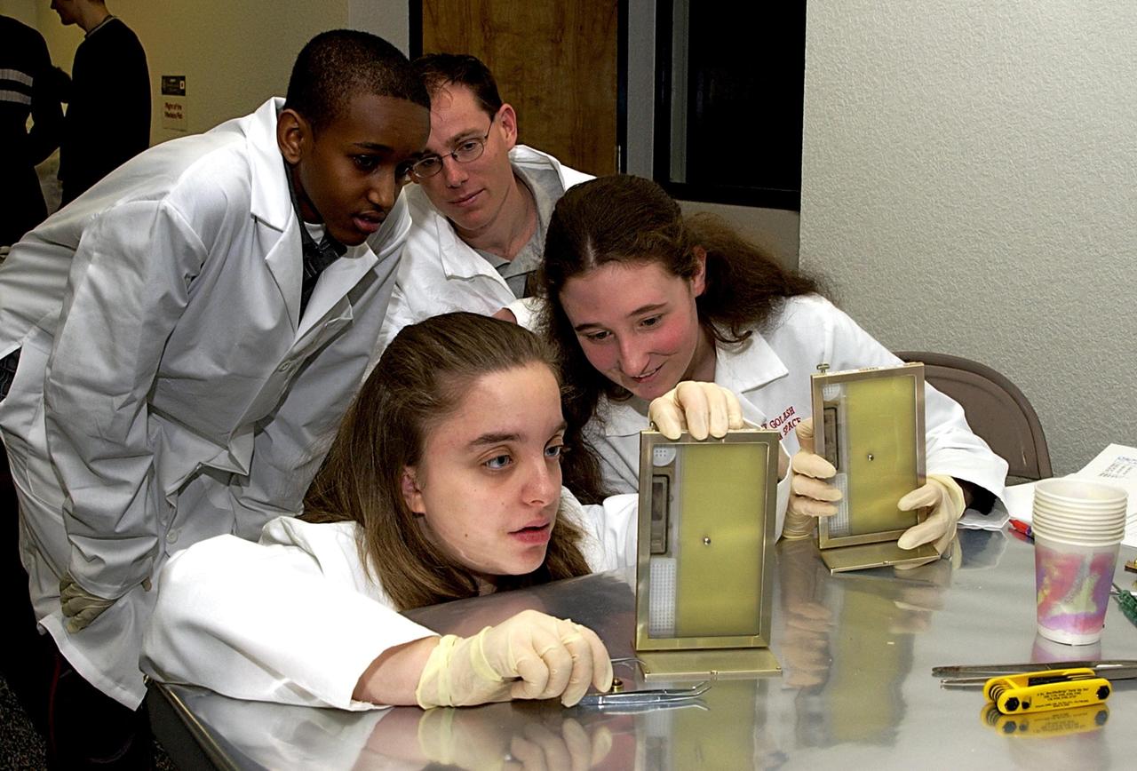 KENNEDY SPACE CENTER, FLA. - Students check on their experiments that will fly in SPACEHAB on Space Shuttle Columbia on mission STS-107. SPACEHAB's complement of commercial experiments includes six educational experiments designed and developed by students in six different countries under the auspices of Space Technology and Research Students (STARS), a global education program managed by SPACEHAB subsidiary Space Media. The countries represented are Australia, China, Israel, Japan, Liechtenstein and the United States. The student investigators who conceived these experiments will monitor their operations in space. The experiments will be housed in BioServe Space Technologies' Isothermal Containment Module (ICM --a small temperature-controlled facility that provides experiment support such as physical containment, lighting, and video imaging) and stowed in a middeck-size locker aboard the SPACEHAB Research Double Module.