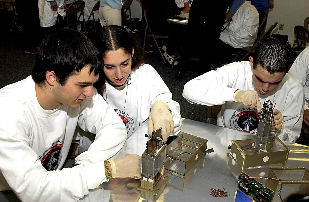 KENNEDY SPACE CENTER, FLA. - Students work on their experiments that will fly in SPACEHAB on Space Shuttle Columbia on mission STS-107. SPACEHAB's complement of commercial experiments includes six educational experiments designed and developed by students in six different countries under the auspices of Space Technology and Research Students (STARS), a global education program managed by SPACEHAB subsidiary Space Media. The countries represented are Australia, China, Israel, Japan, Liechtenstein and the United States. The student investigators who conceived these experiments will monitor their operations in space. The experiments will be housed in BioServe Space Technologies' Isothermal Containment Module (ICM --a small temperature-controlled facility that provides experiment support such as physical containment, lighting, and video imaging) and stowed in a middeck-size locker aboard the SPACEHAB Research Double Module.