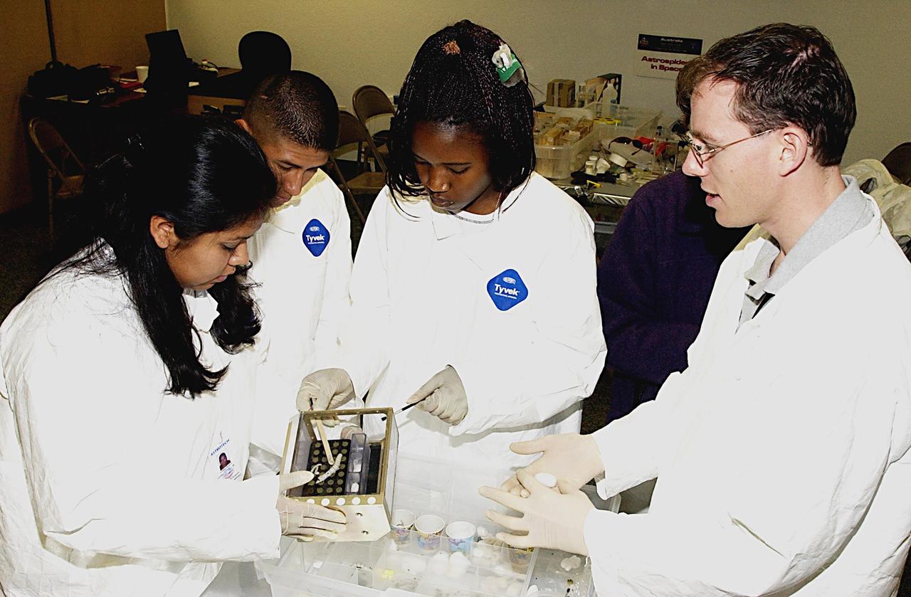 KENNEDY SPACE CENTER, FLA. - Students work on their experiments that will fly in SPACEHAB on Space Shuttle Columbia on mission STS-107. SPACEHAB's complement of commercial experiments includes six educational experiments designed and developed by students in six different countries under the auspices of Space Technology and Research Students (STARS), a global education program managed by SPACEHAB subsidiary Space Media. The countries represented are Australia, China, Israel, Japan, Liechtenstein and the United States. The student investigators who conceived these experiments will monitor their operations in space. The experiments will be housed in BioServe Space Technologies' Isothermal Containment Module (ICM --a small temperature-controlled facility that provides experiment support such as physical containment, lighting, and video imaging) and stowed in a middeck-size locker aboard the SPACEHAB Research Double Module.