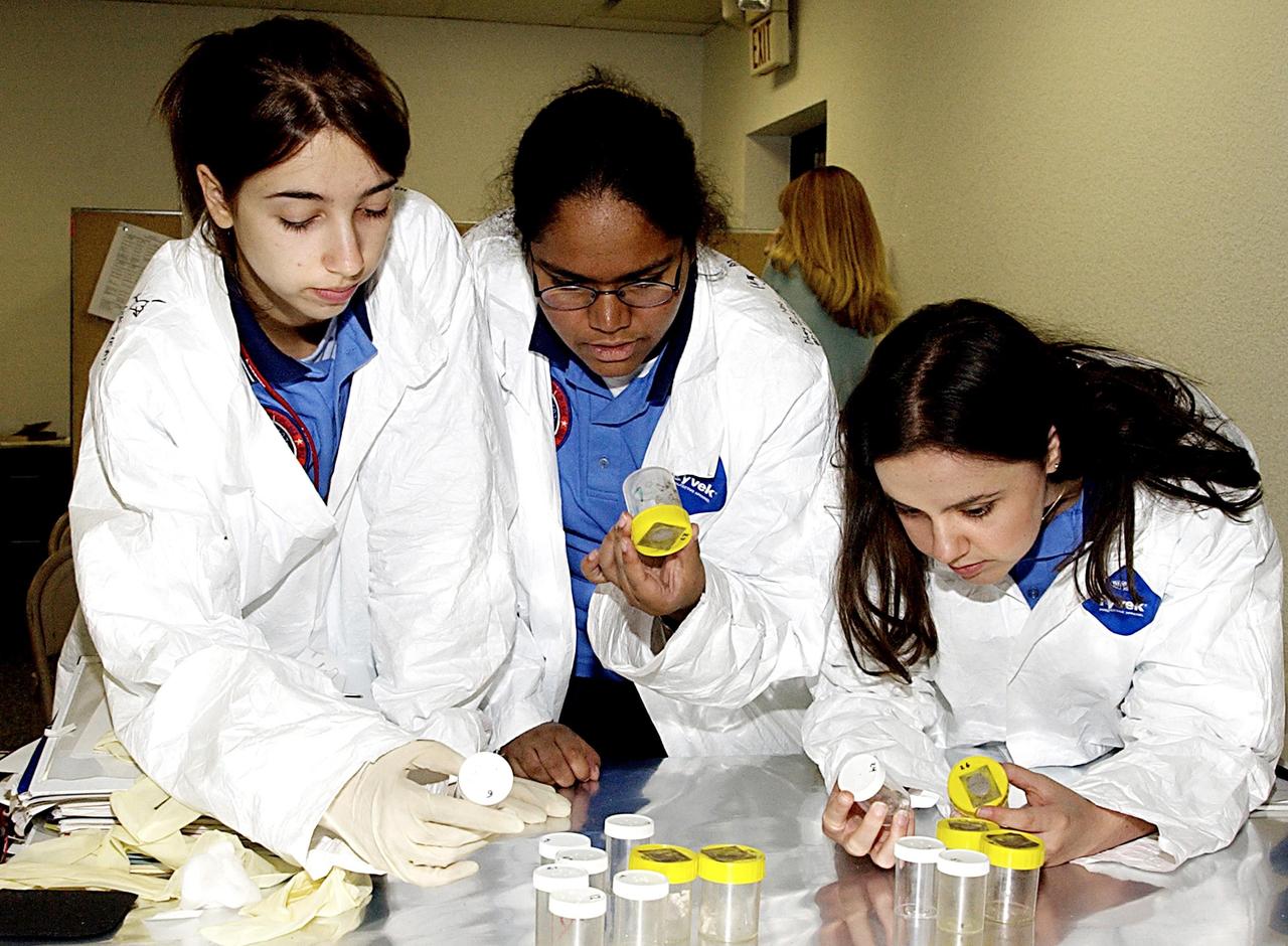 KENNEDY SPACE CENTER, FLA. - Students check out their experiments that will fly in SPACEHAB on Space Shuttle Columbia on mission STS-107. SPACEHAB's complement of commercial experiments includes six educational experiments designed and developed by students in six different countries under the auspices of Space Technology and Research Students (STARS), a global education program managed by SPACEHAB subsidiary Space Media. The countries represented are Australia, China, Israel, Japan, Liechtenstein and the United States. The student investigators who conceived these experiments will monitor their operations in space. The experiments will be housed in BioServe Space Technologies' Isothermal Containment Module (ICM --a small temperature-controlled facility that provides experiment support such as physical containment, lighting, and video imaging) and stowed in a middeck-size locker aboard the SPACEHAB Research Double Module.