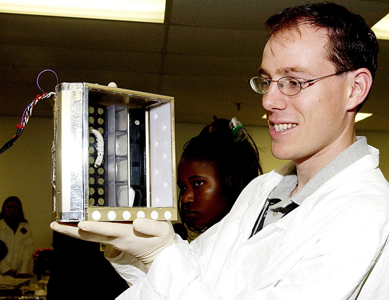 KENNEDY SPACE CENTER, FLA. - A student shows off one of the experiments that will fly in SPACEHAB on Space Shuttle Columbia on mission STS-107. SPACEHAB's complement of commercial experiments includes six educational experiments designed and developed by students in six different countries under the auspices of Space Technology and Research Students (STARS), a global education program managed by SPACEHAB subsidiary Space Media. The countries represented are Australia, China, Israel, Japan, Liechtenstein and the United States. The student investigators who conceived these experiments will monitor their operations in space. The experiments will be housed in BioServe Space Technologies' Isothermal Containment Module (ICM --a small temperature-controlled facility that provides experiment support such as physical containment, lighting, and video imaging) and stowed in a middeck-size locker aboard the SPACEHAB Research Double Module.