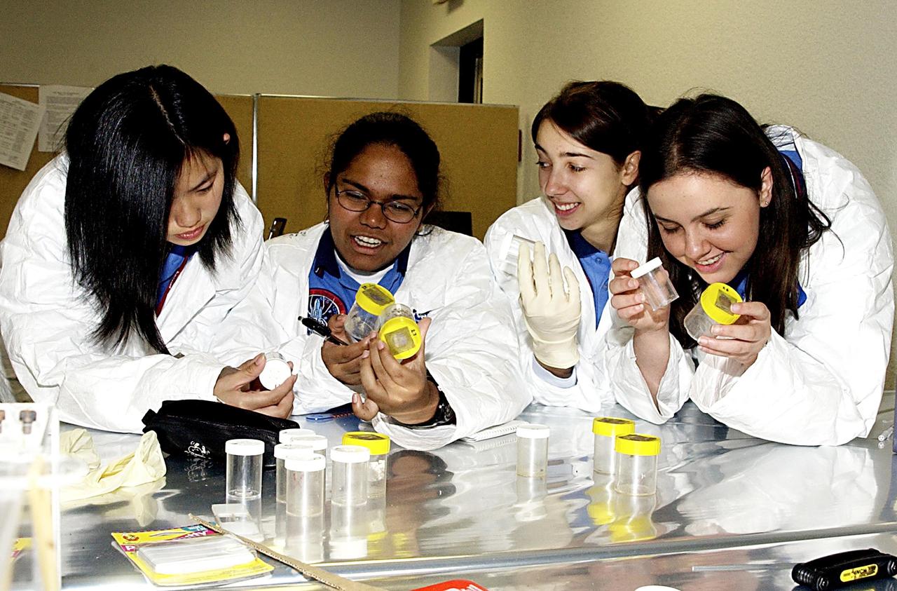 KENNEDY SPACE CENTER, FLA. -- Students check out their experiments that will fly in SPACEHAB on Space Shuttle Columbia on mission STS-107. SPACEHAB's complement of commercial experiments includes six educational experiments designed and developed by students in six different countries under the auspices of Space Technology and Research Students (STARS), a global education program managed by SPACEHAB subsidiary Space Media. The countries represented are Australia, China, Israel, Japan, Liechtenstein and the United States. The student investigators who conceived these experiments will monitor their operations in space. The experiments will be housed in BioServe Space Technologies' Isothermal Containment Module (ICM --a small temperature-controlled facility that provides experiment support such as physical containment, lighting, and video imaging) and stowed in a middeck-size locker aboard the SPACEHAB Research Double Module.