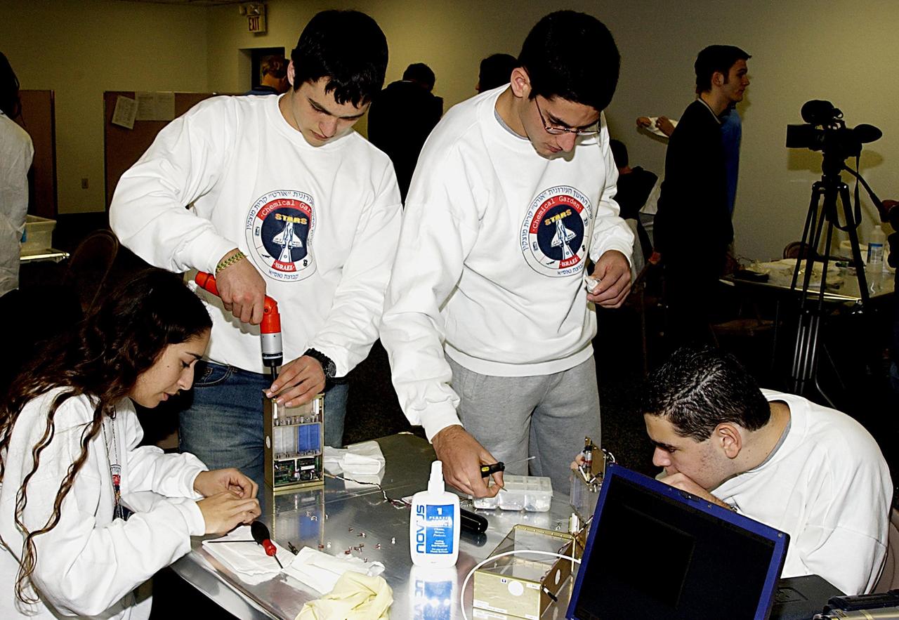 KENNEDY SPACE CENTER, FLA. -- Students work on their experiments that will fly in SPACEHAB on Space Shuttle Columbia on mission STS-107. SPACEHAB's complement of commercial experiments includes six educational experiments designed and developed by students in six different countries under the auspices of Space Technology and Research Students (STARS), a global education program managed by SPACEHAB subsidiary Space Media. The countries represented are Australia, China, Israel, Japan, Liechtenstein and the United States. The student investigators who conceived these experiments will monitor their operations in space. The experiments will be housed in BioServe Space Technologies' Isothermal Containment Module (ICM --a small temperature-controlled facility that provides experiment support such as physical containment, lighting, and video imaging) and stowed in a middeck-size locker aboard the SPACEHAB Research Double Module.