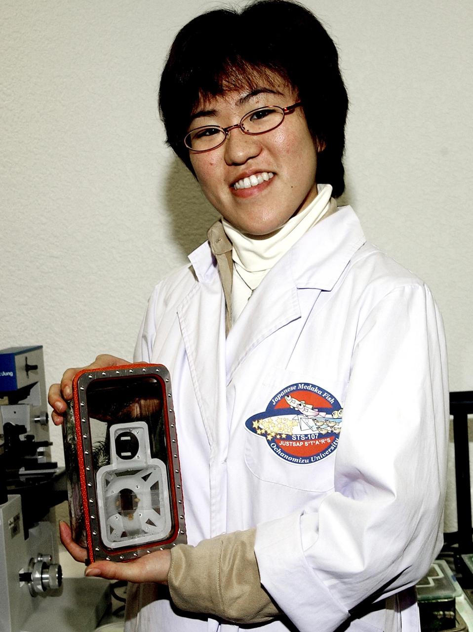 KENNEDY SPACE CENTER, FLA. -- A student displays an experiment that will fly in SPACEHAB on Space Shuttle Columbia on mission STS-107. SPACEHAB's complement of commercial experiments includes six educational experiments designed and developed by students in six different countries under the auspices of Space Technology and Research Students (STARS), a global education program managed by SPACEHAB subsidiary Space Media. The countries represented are Australia, China, Israel, Japan, Liechtenstein and the United States. The student investigators who conceived these experiments will monitor their operations in space. The experiments will be housed in BioServe Space Technologies' Isothermal Containment Module (ICM --a small temperature-controlled facility that provides experiment support such as physical containment, lighting, and video imaging) and stowed in a middeck-size locker aboard the SPACEHAB Research Double Module.