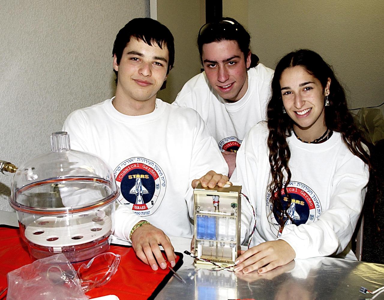 KENNEDY SPACE CENTER, FLA. -- Students display an experiment that will fly in SPACEHAB on Space Shuttle Columbia on mission STS-107. SPACEHAB's complement of commercial experiments includes six educational experiments designed and developed by students in six different countries under the auspices of Space Technology and Research Students (STARS), a global education program managed by SPACEHAB subsidiary Space Media. The countries represented are Australia, China, Israel, Japan, Liechtenstein and the United States. The student investigators who conceived these experiments will monitor their operations in space. The experiments will be housed in BioServe Space Technologies' Isothermal Containment Module (ICM --a small temperature-controlled facility that provides experiment support such as physical containment, lighting, and video imaging) and stowed in a middeck-size locker aboard the SPACEHAB Research Double Module.