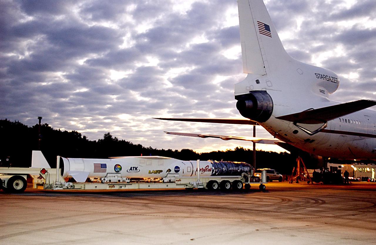 KENNEDY SPACE CENTER, FLA. - The Pegasus XL launch vehicle, with the Solar Radiation and Climate Experiment (SORCE) satellite aboard, arrives at Cape Canaveral Air Force Station (CCAFS), Fla. At right is the L-1011 aircraft that will carry the Pegasus to the launch altitude of 39,000 feet over the Atlantic Ocean approximately 100 miles east-southeast of Cape Canaveral. SORCE, built by Orbital Sciences Corporation, will study and measure solar irradiance as a source of energy in the Earth's atmosphere. The launch of SORCE is scheduled for Jan. 25 at 3:14 p.m. from CCAFS.