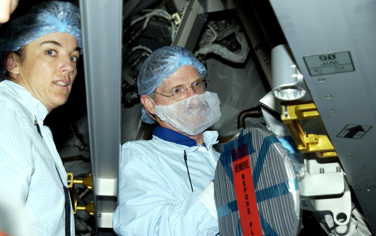 KENNEDY SPACE CENTER, FLA. -- During Crew Equipment Interface Test activities in the Space Station Processing Facility, STS-115 Mission Specialists Heidemarie Stefanyshyn-Piper and Joseph Tanner look at equipment. The mission will deliver the second port truss segment, the P3/P4 Truss, to attach to the first port truss segment, the P1 Truss, as well as deploy solar array set 2A and 4A.  Launch on Space Shuttle Endeavour is scheduled for May 23, 2003.    