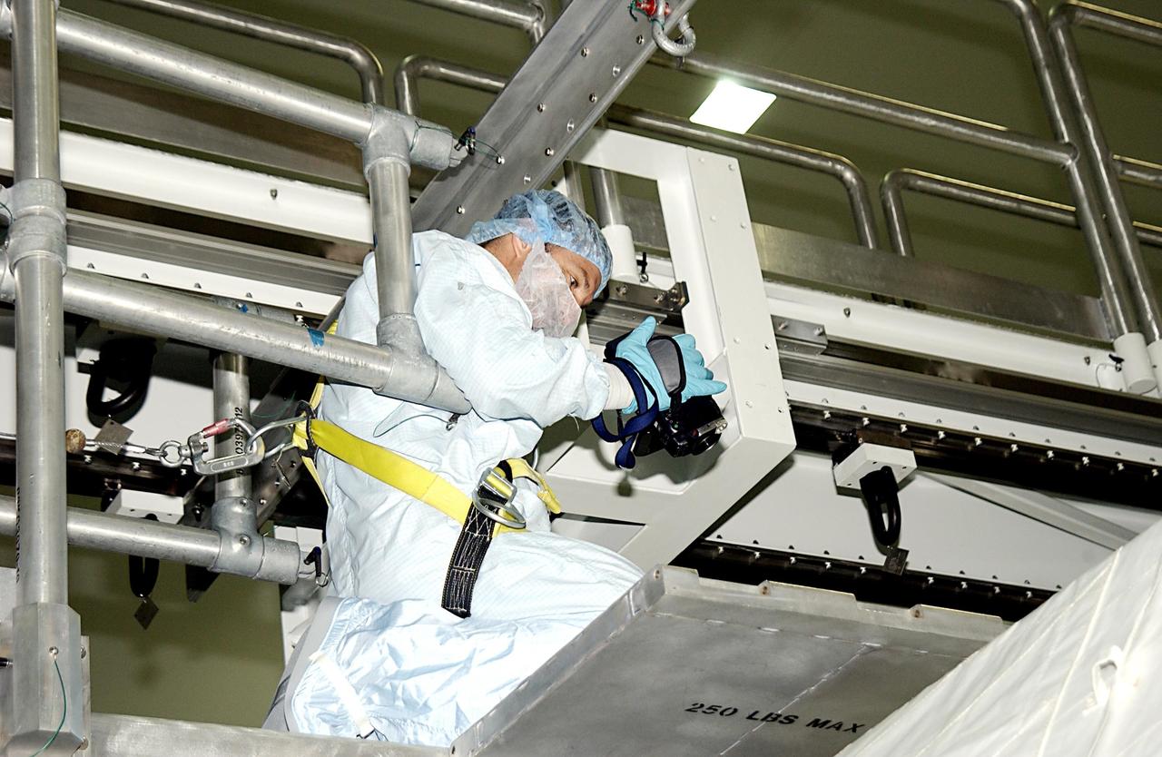 KENNEDY SPACE CENTER, FLA. -- STS-115 Mission Specialist Daniel Burbank checks out equipment during Crew Equipment Interface Test activities in the Space Station Processing Facility. The mission will deliver the second port truss segment, the P3/P4 Truss, to attach to the first port truss segment, the P1 Truss, as well as deploy solar array set 2A and 4A.  Launch on Space Shuttle Endeavour is scheduled for May 23, 2003.   