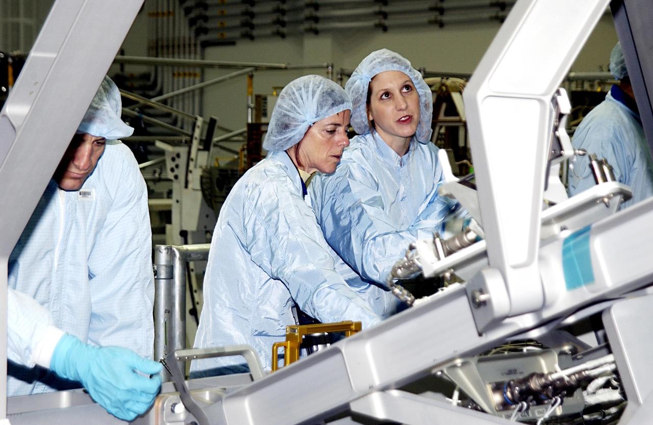 KENNEDY SPACE CENTER, FLA. - In the Space Station Processing Facility, STS-118 Pilot Charles Hobaugh (left) and Mission Specialist Barbara Morgan look over part of the mission payload. At right is a technician.  Morgan was selected by NASA in January 1998 as the first Educator Astronaut.  The mission will be delivering the third starboard truss segment, the ITS S5, to the International Space Station, and a SPACEHAB Single Cargo Module with supplies and equipment.  Launch aboard Space Shuttle Columbia is scheduled for Nov. 13, 2003.  