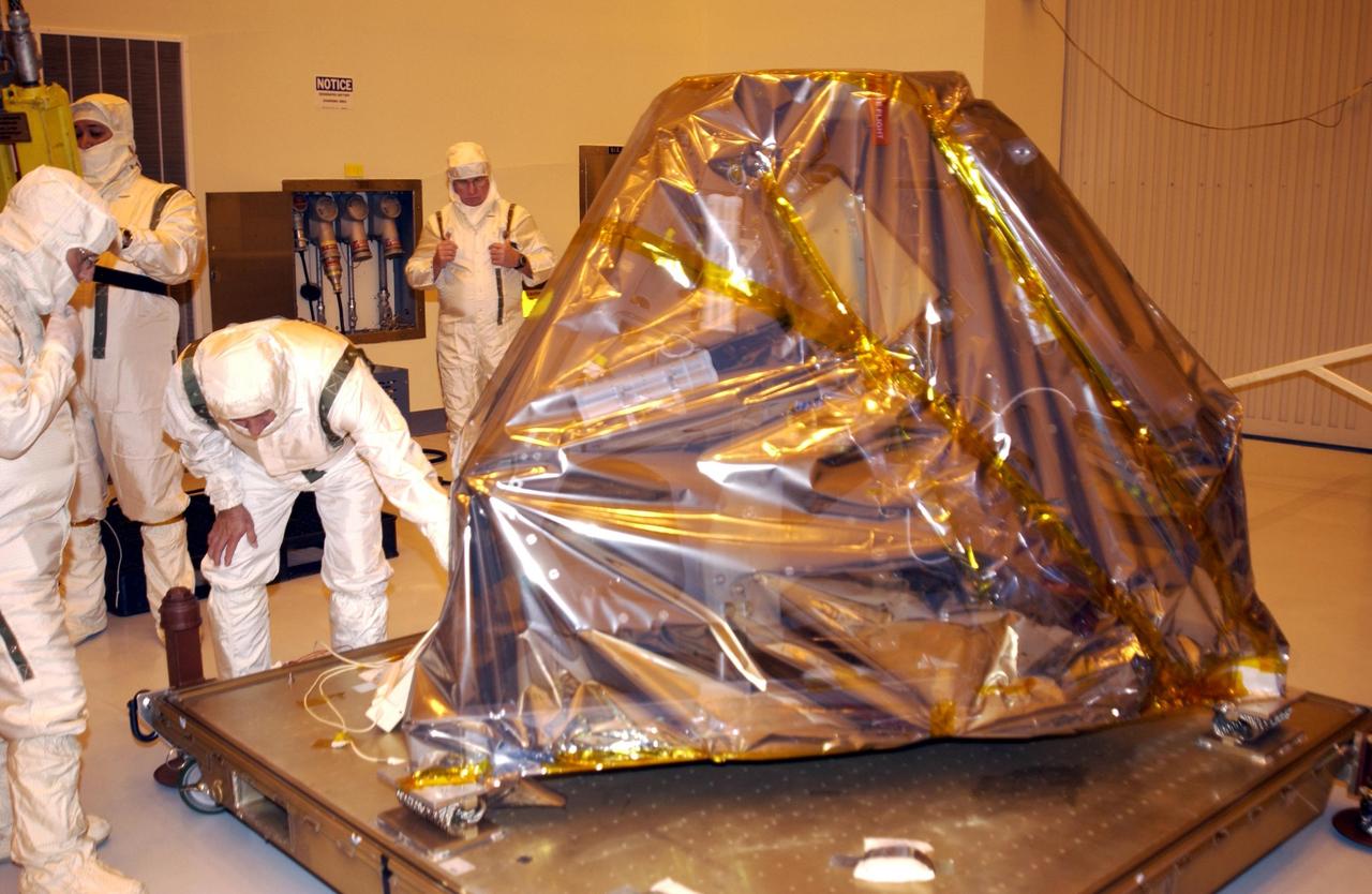 KENNEDY SPACE CENTER, FLA. -- In the Payload Hazardous Servicing Facility, workers get ready to remove the plastic covering from the Mars Exploration Rover -2. Set to launch in 2003, the Mars Exploration Rover Mission will consist of two identical rovers designed to cover roughly 110 yards (100 meters) each Martian day. Each rover will carry five scientific instruments that will allow it to search for evidence of liquid water that may have been present in the planet's past.  The rovers will be identical to each other, but will land at different regions of Mars.  The first rover has a launch window opening May 30, 2003, and the second rover a window opening June 25, 2003.